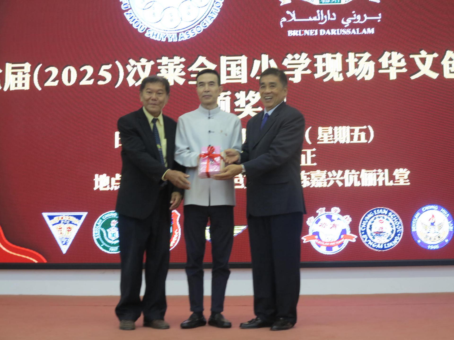 刘世泉博士赠送纪念品予肖建国大使，左为黄林明