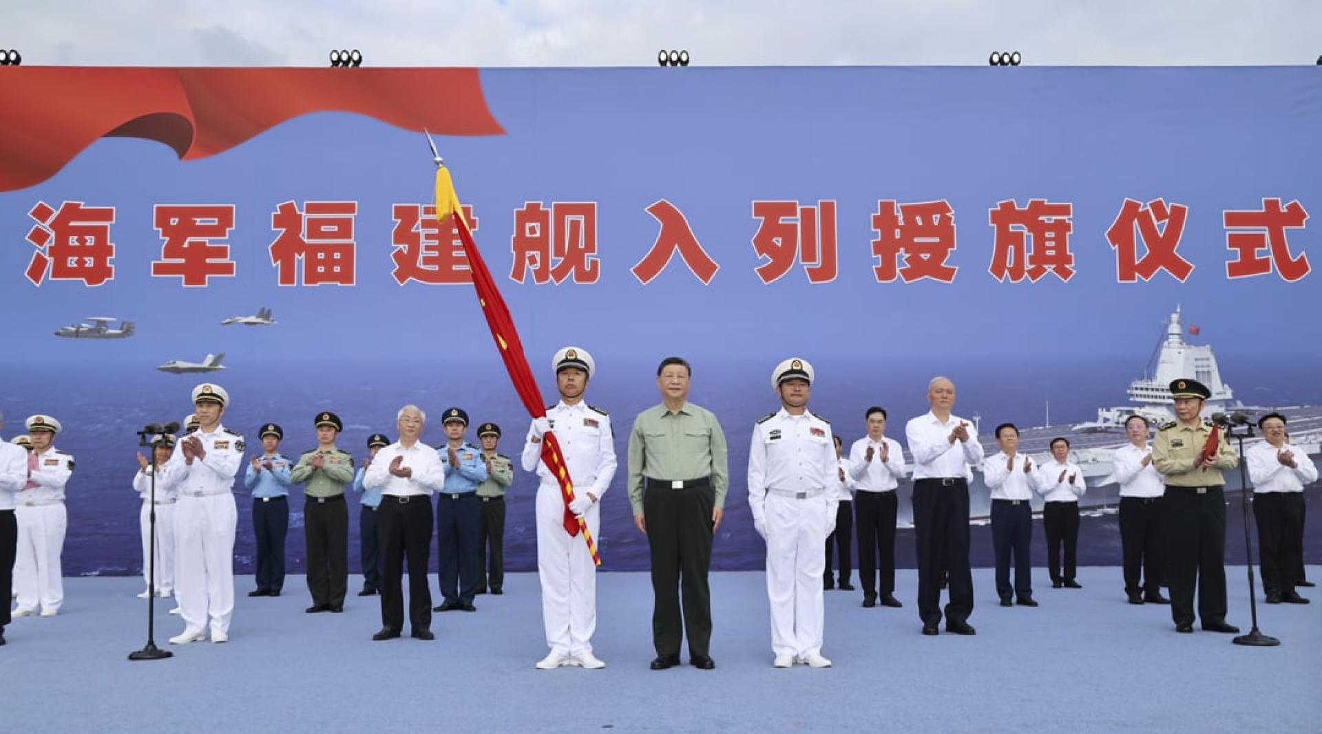 习近平向福建舰舰长、政治委员授予军旗。（图：新华社）