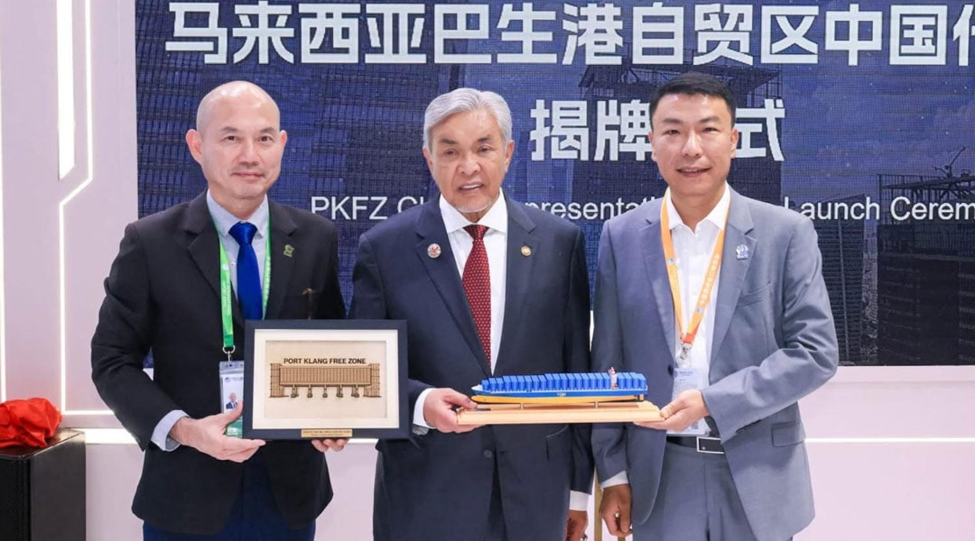 林立迎（左起）、阿末扎希和周诗豪，在上海的进博会交换纪念品。