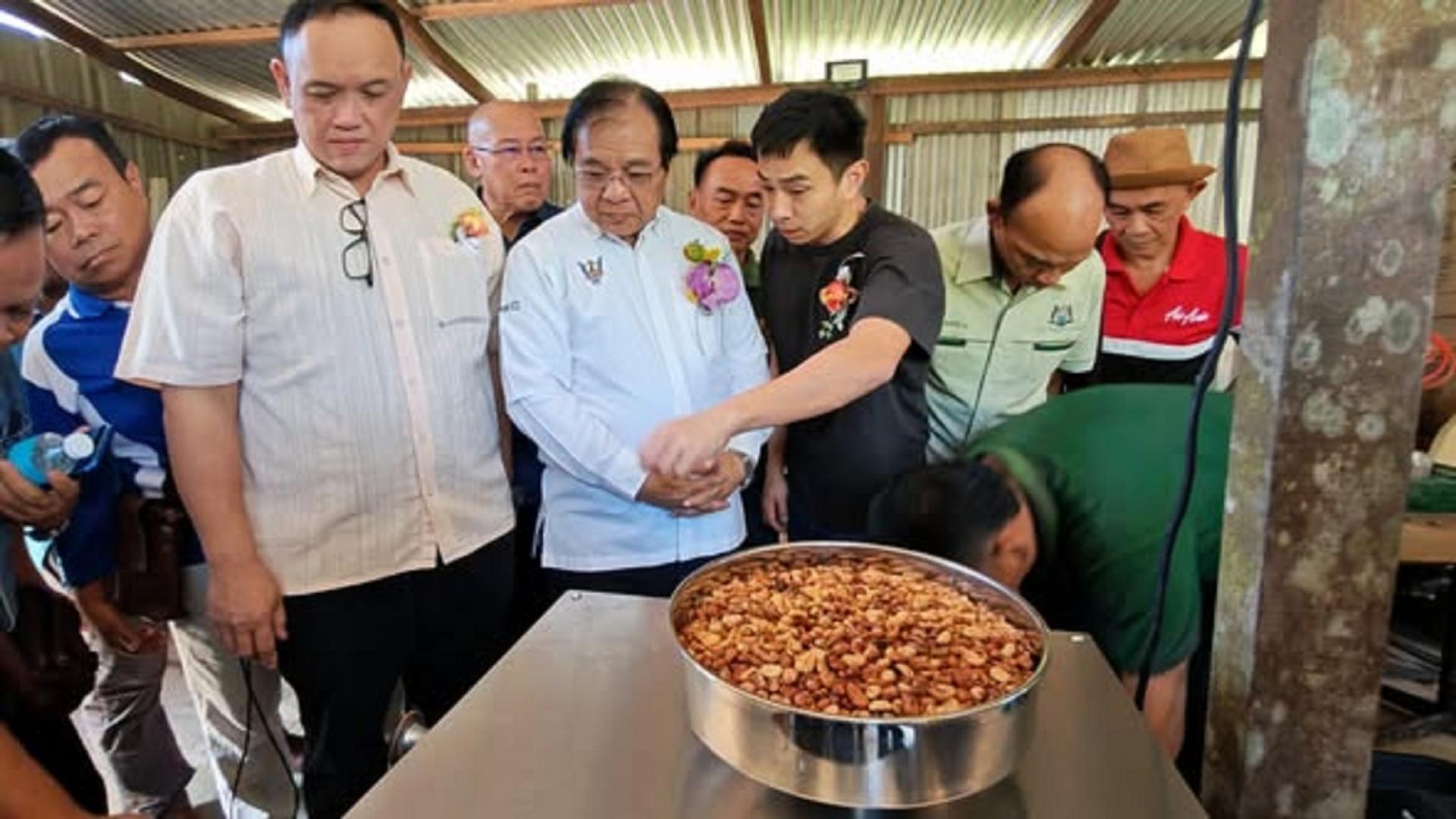 咖啡业者向拿督耶里苏修（中）介绍所生产的咖啡粒。