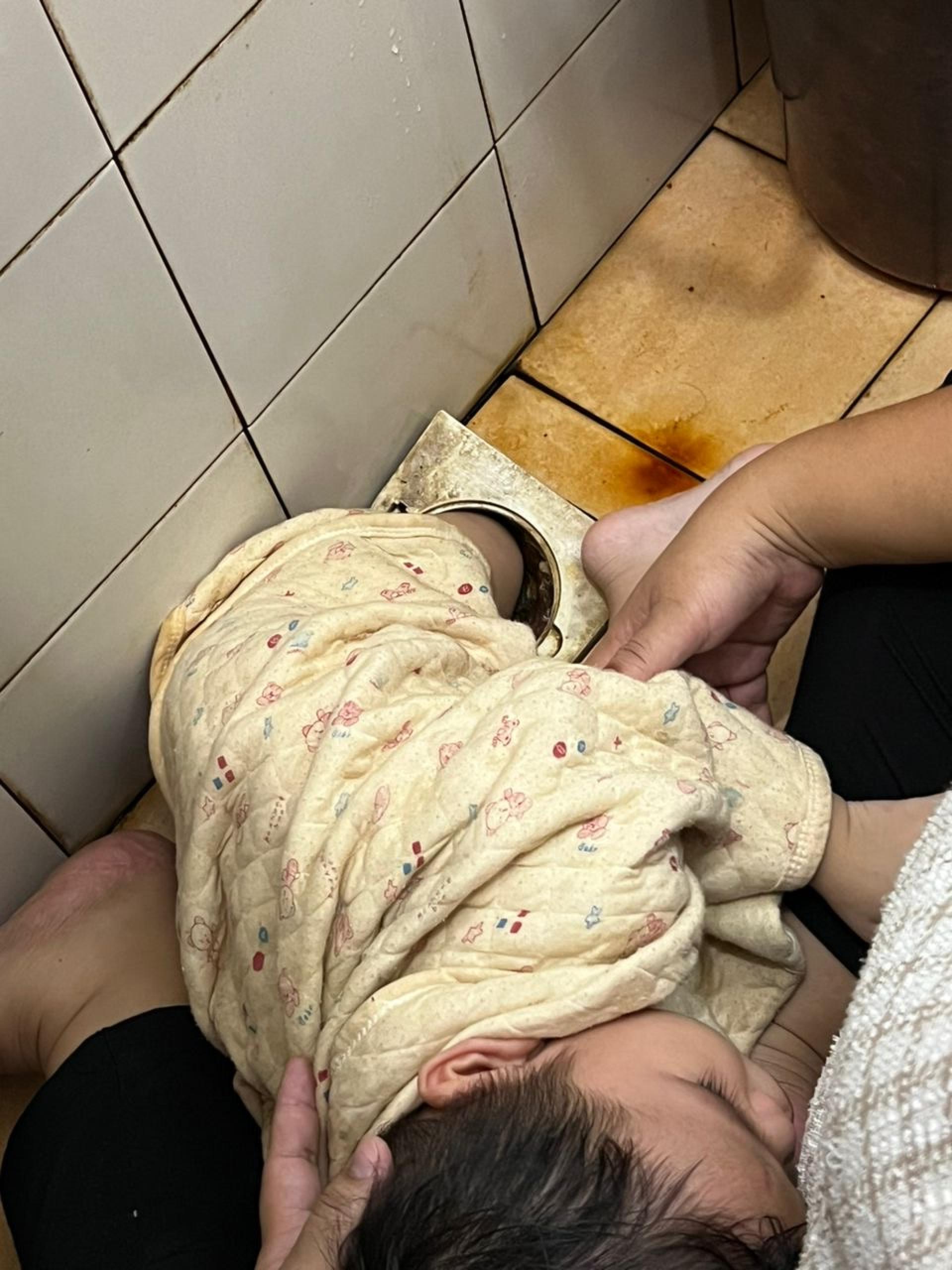 小童的左脚被困在浴室排水孔内。