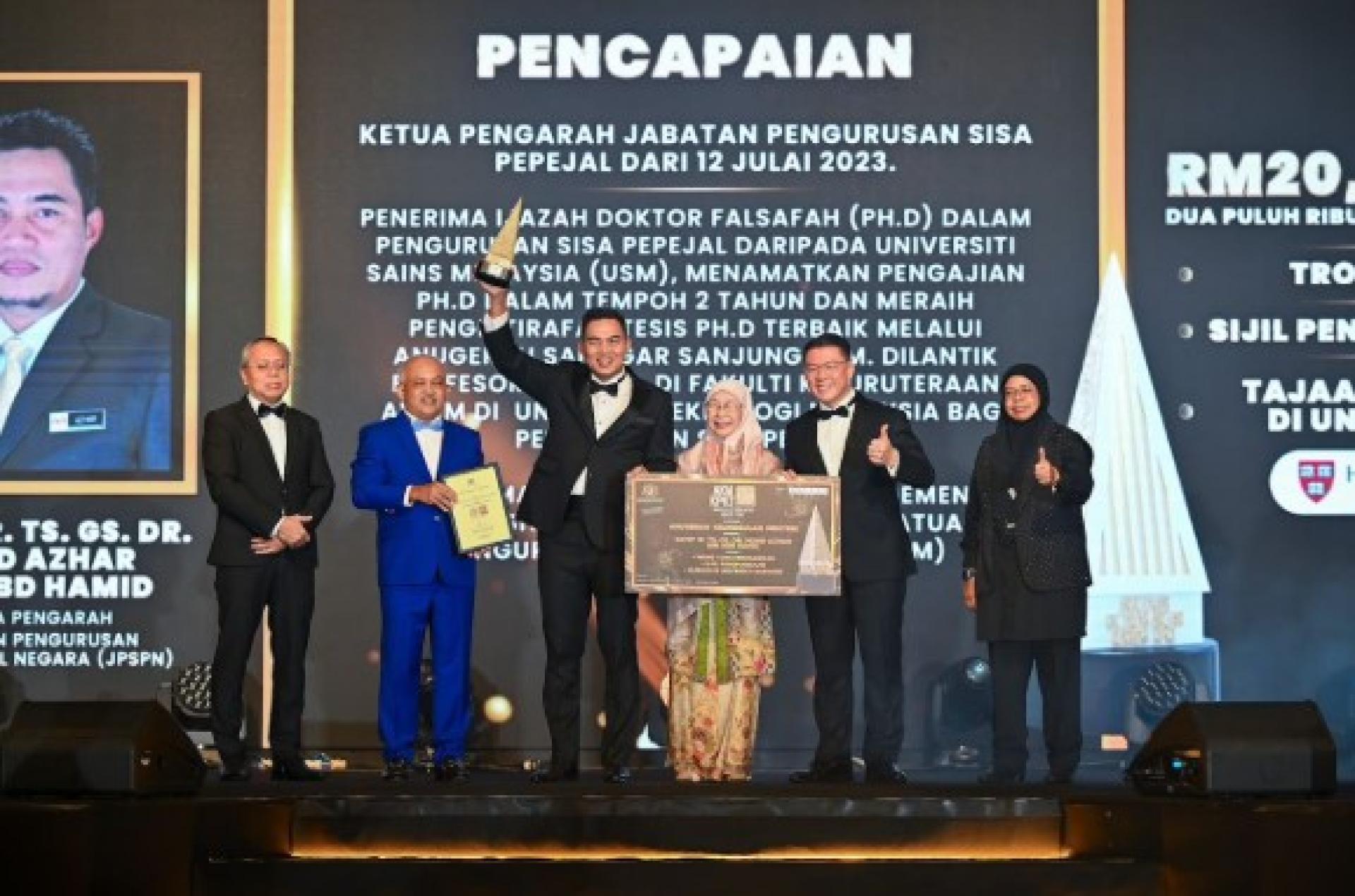 阿兹哈（左3起）荣获“部长卓越表现奖”后高举奖杯，与旺阿兹莎及倪可敏等人合照。