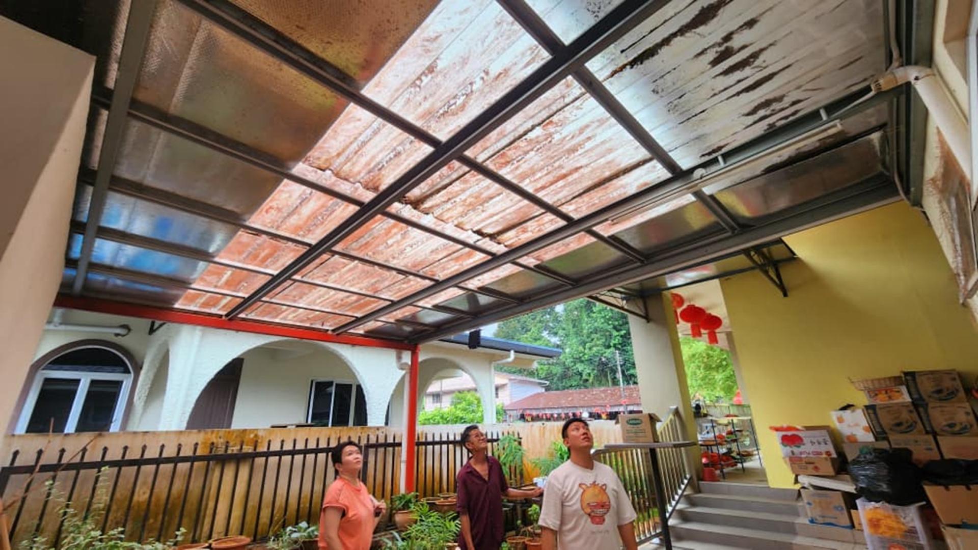 沈杰龙（右）在负责人的带领下，巡视Lorong Upland 7 拿督公庙其中一项屋顶维修工程等。