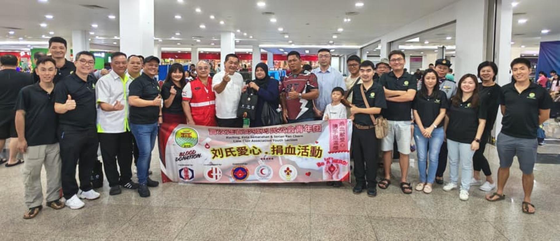 峇都林当区立法议员施志豪 (中) 移交礼品予成功捐血者。左二起为刘青团刘儱语市议员、刘青团名誉团长刘善顺和刘时财，左五起为刘青团团长刘慧玲、古晋区红新月会血液征求组主席杨民士。后排右二起为刘青团顾问刘秀真、古晋童子军第14团代表赖思伲、右六为华青团团长郑国栋市议员。