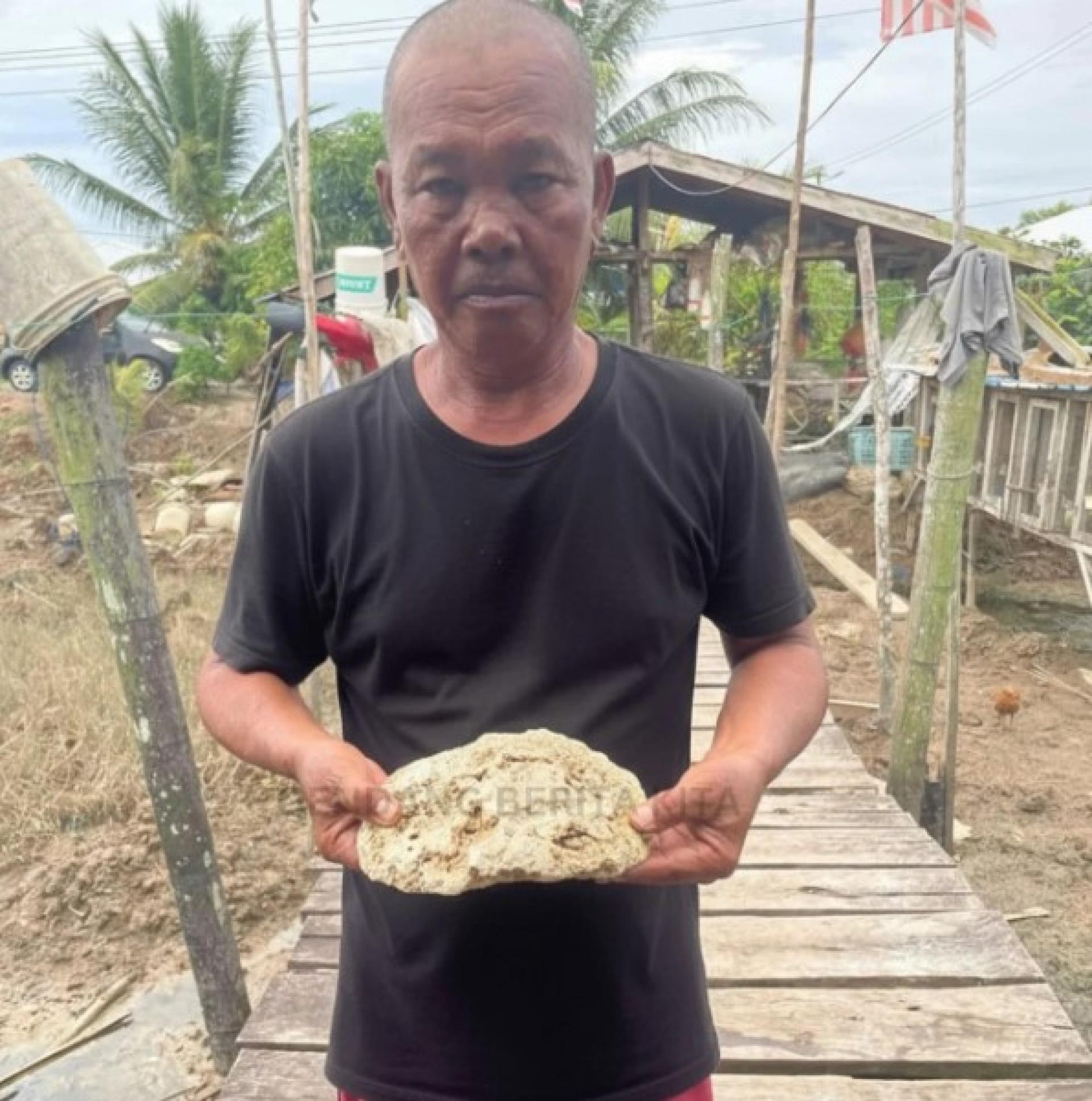 巴拉威渔民沙玛威·曼塔里展示他在瓜拉巴拉威海域发现、重约1.2公斤的可疑物质，疑似为珍贵的“龙涎香”。