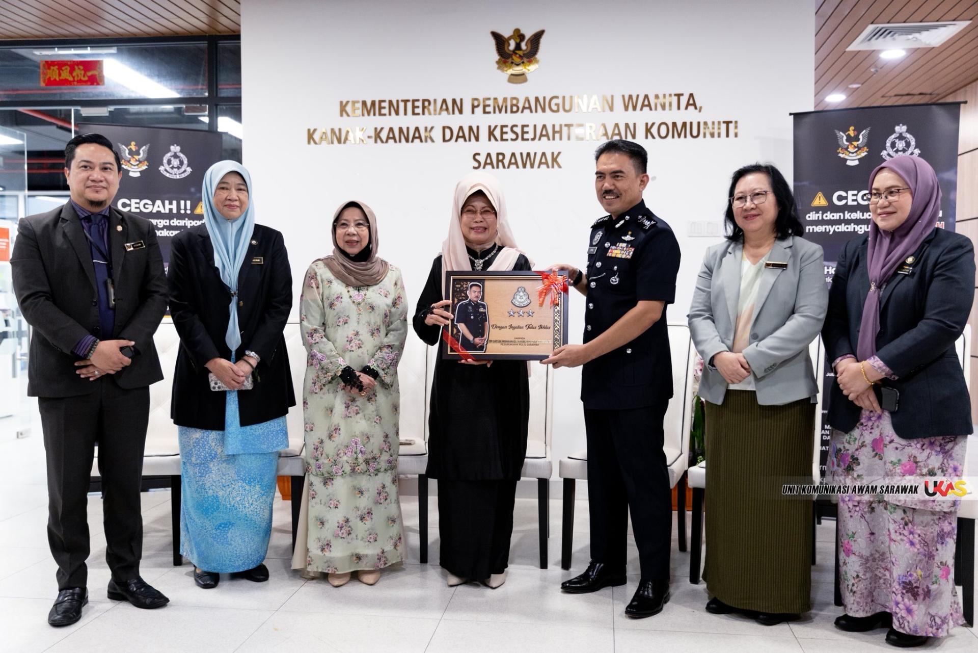 砂拉越警察总监拿督再纳阿都拉（右3）赠送纪念品给拿督斯里陈赛明。