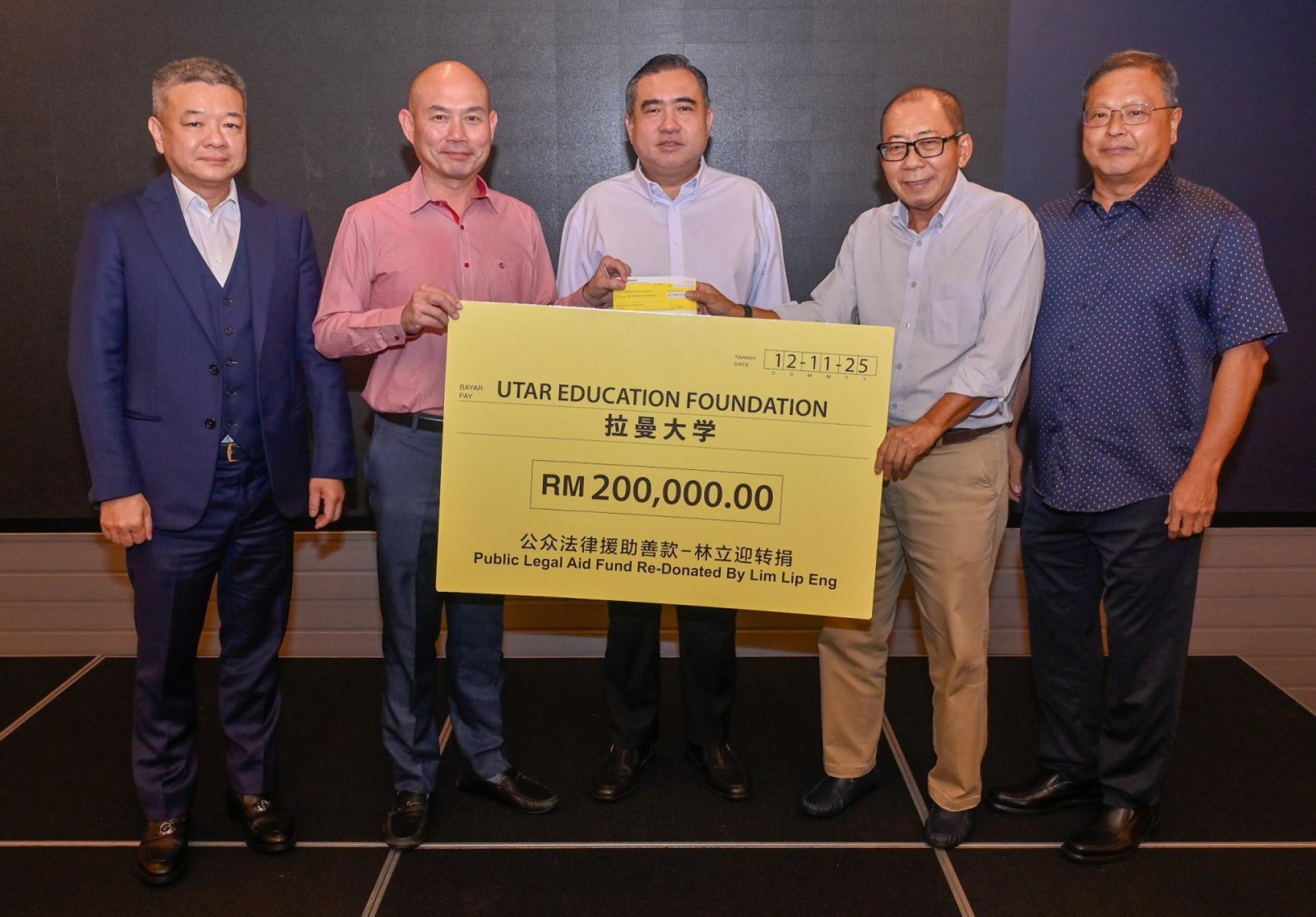 林立迎（左2）在郭义雄（左起）、陆兆福及李斯能（右）的见证下，将20万令吉移交给曹智雄（右2）。