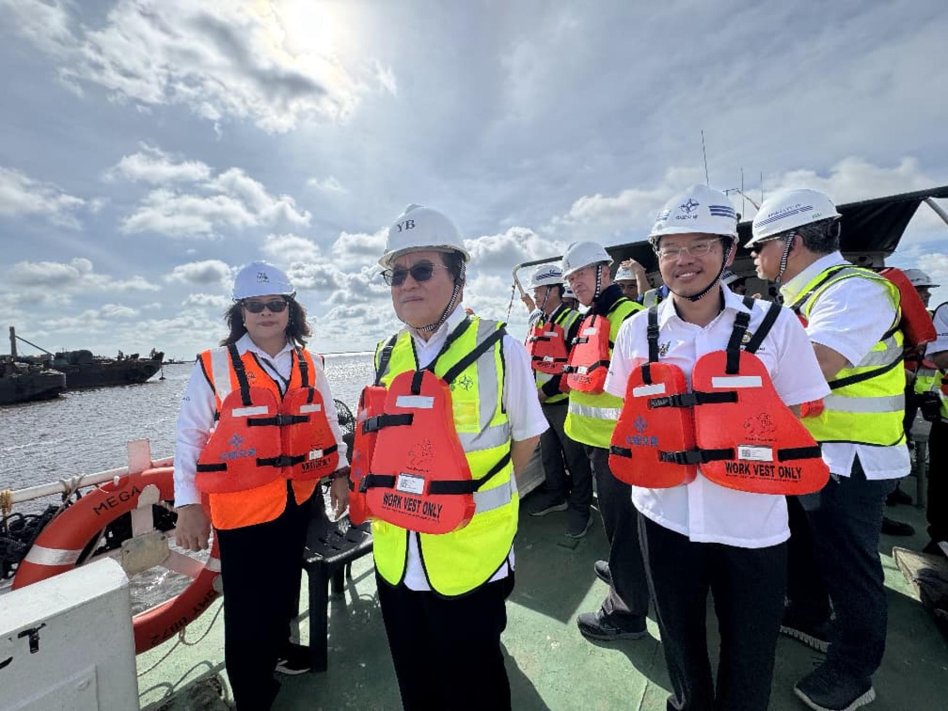 道格拉斯（左2）率众乘船出海巡视工程。