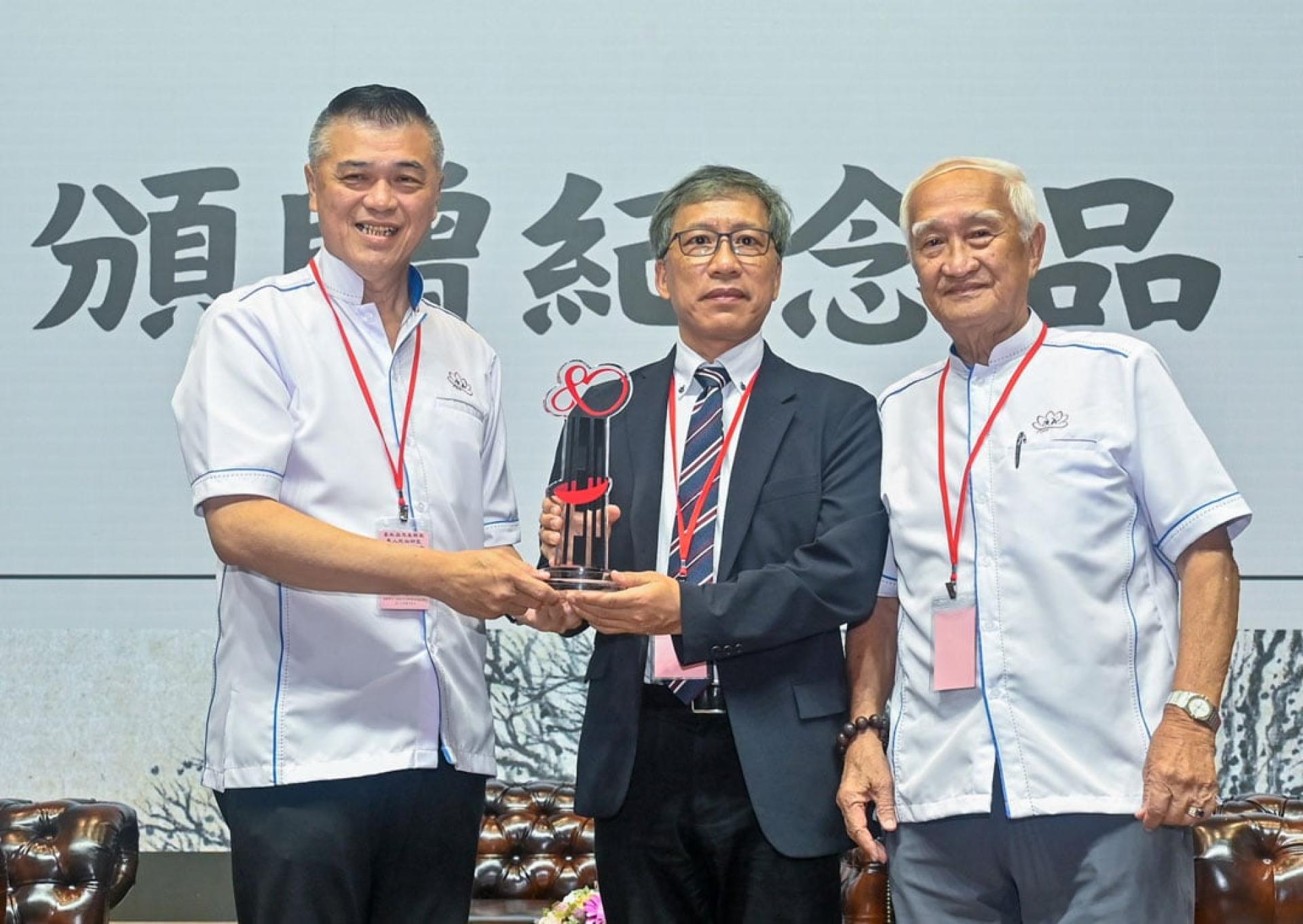 杨博耀（左起）将纪念品赠予江柏炜，右为郑金德。