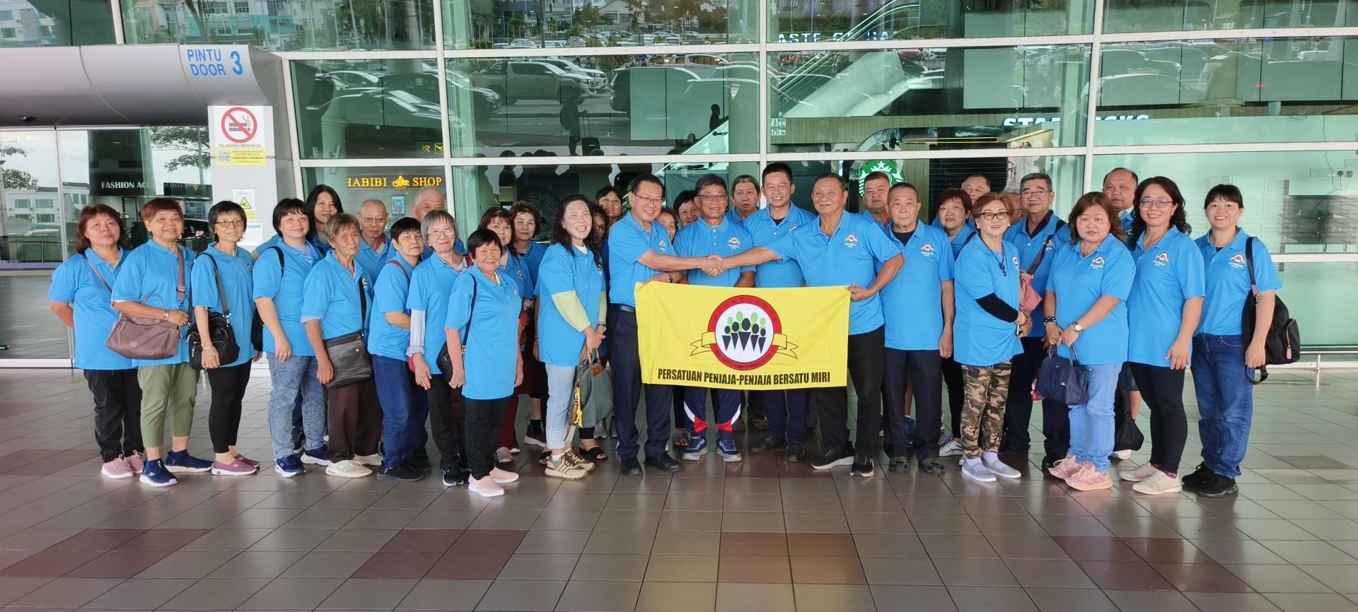 砂交通部长拿督斯里李景胜（左10）在美里机场授旗予美里小贩联合会主席张启创，并与全体代表团成员合影。