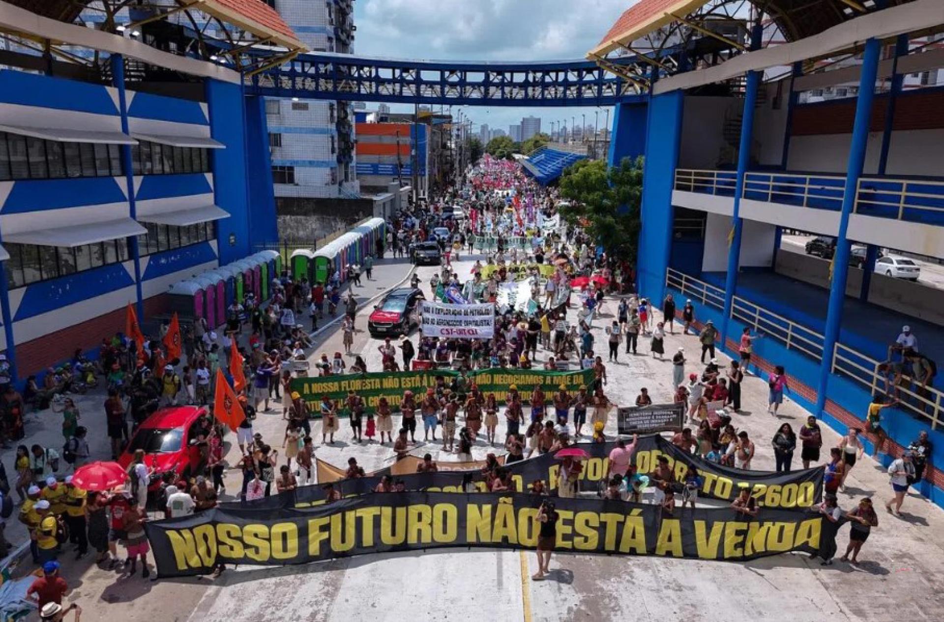 大批活动人士星期六（11月15日）走上贝伦街头，顶着烈日和平示威，图中的巨幅口号写着：“我们的未来不容出售”。