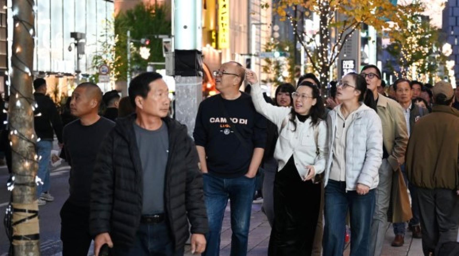 中国游客15日在东京银座购物区漫步。