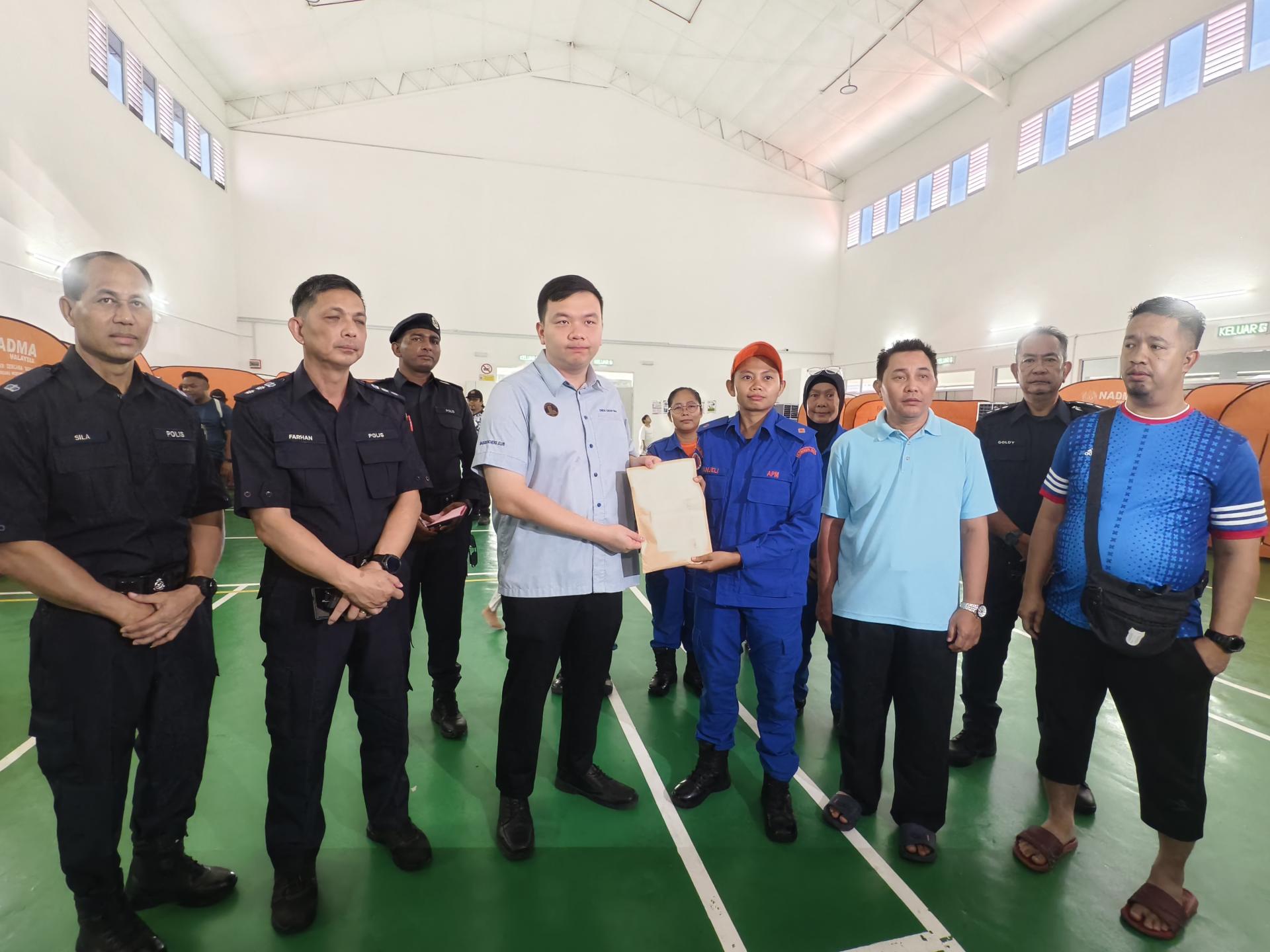 美里国会议员赵俊文（左3）移交紧急援助金，由民防部队代为接收与移交给受灾家庭。