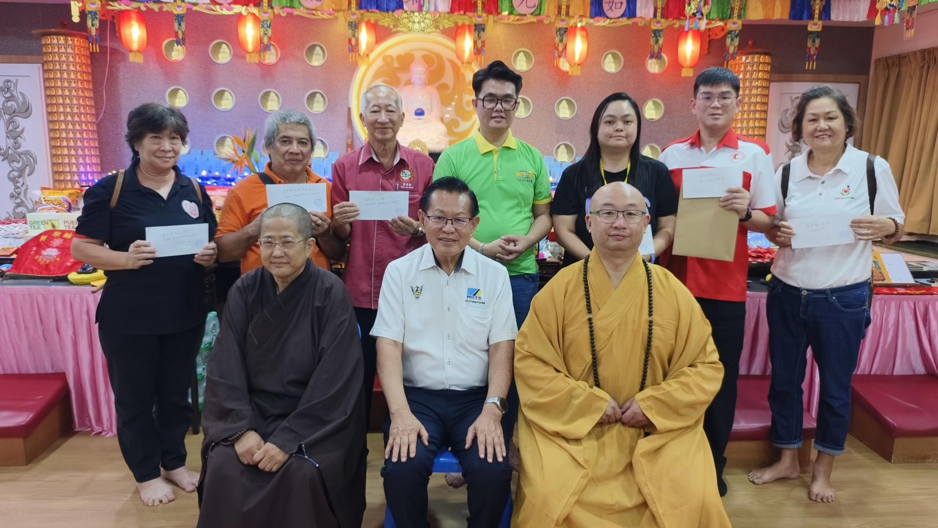 砂交通部长拿督斯里李景胜（中）与“点满愿千灯3.0”筹募善款移交予受惠单位后合影。后排左4为筹备会主席徐奇川。