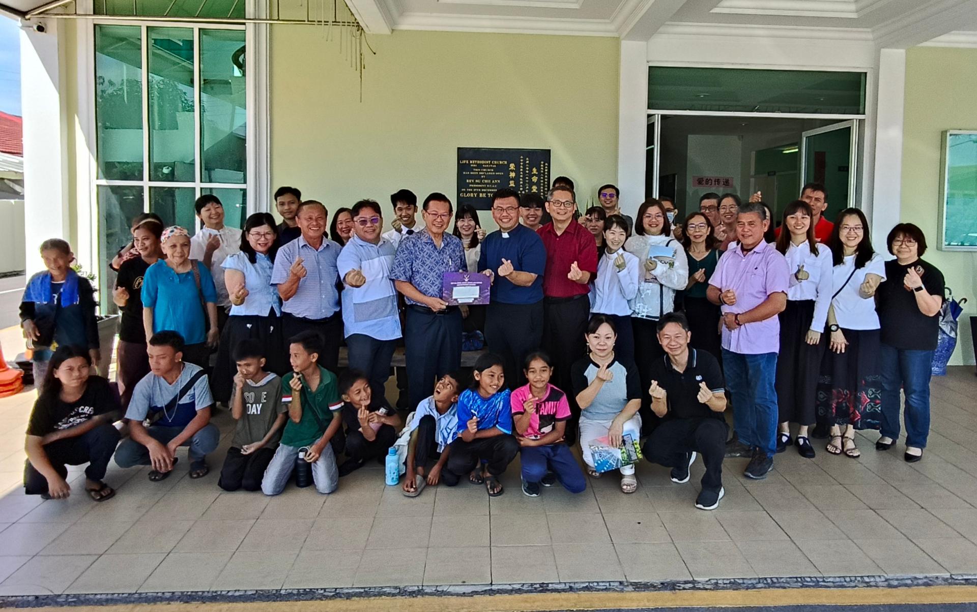 砂交通部长拿督斯里李景胜（左者）代表砂其他宗教事务单位移交15万令吉拨款予美里卫理公会生命堂，由牧师萧明政代表接收。