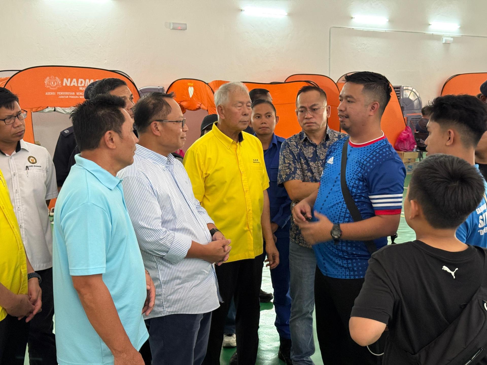 前左2起砂州务秘书莫哈末阿布巴卡与砂旅游部副部长拿督陈超耀在美里红新月会疏散中心慰问灾黎。