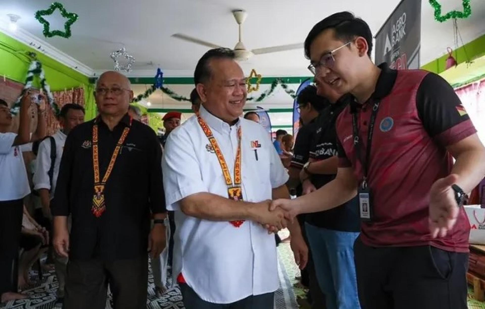 南达（中）在加帛双溪阿芒南甲桑因鲁马贾瓦举办的KEMAS外展计划闭幕仪式上，向一名参与者致意。