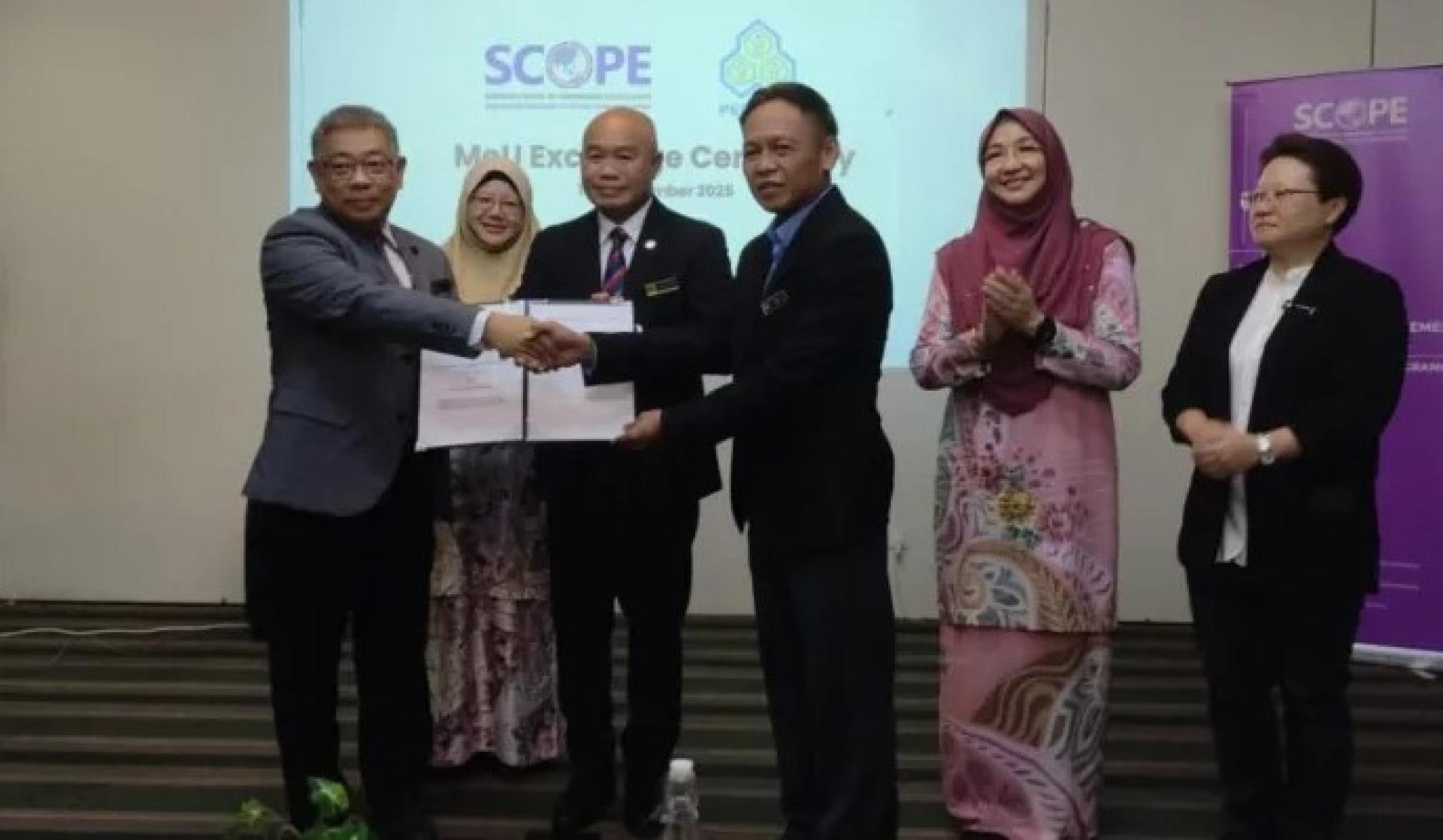 Joseph Lim（左）与Tan Phang Chia（右3）交换SCOPE与PERKESO的MoU协议。