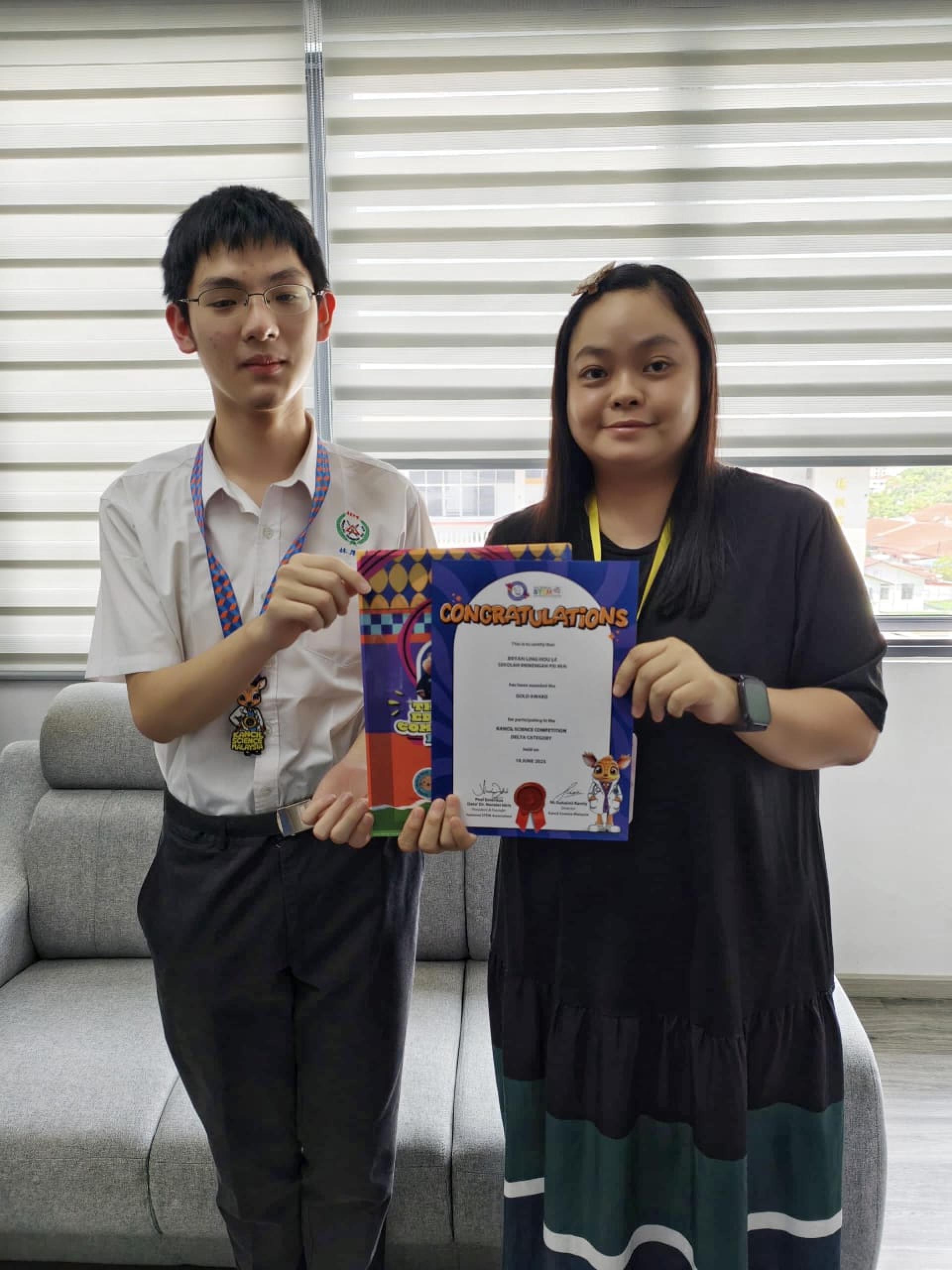 培中生林厚乐(左）在“2025全国鼠鹿科学竞赛”中夺得金奖。右为教务处主任谢依玫。