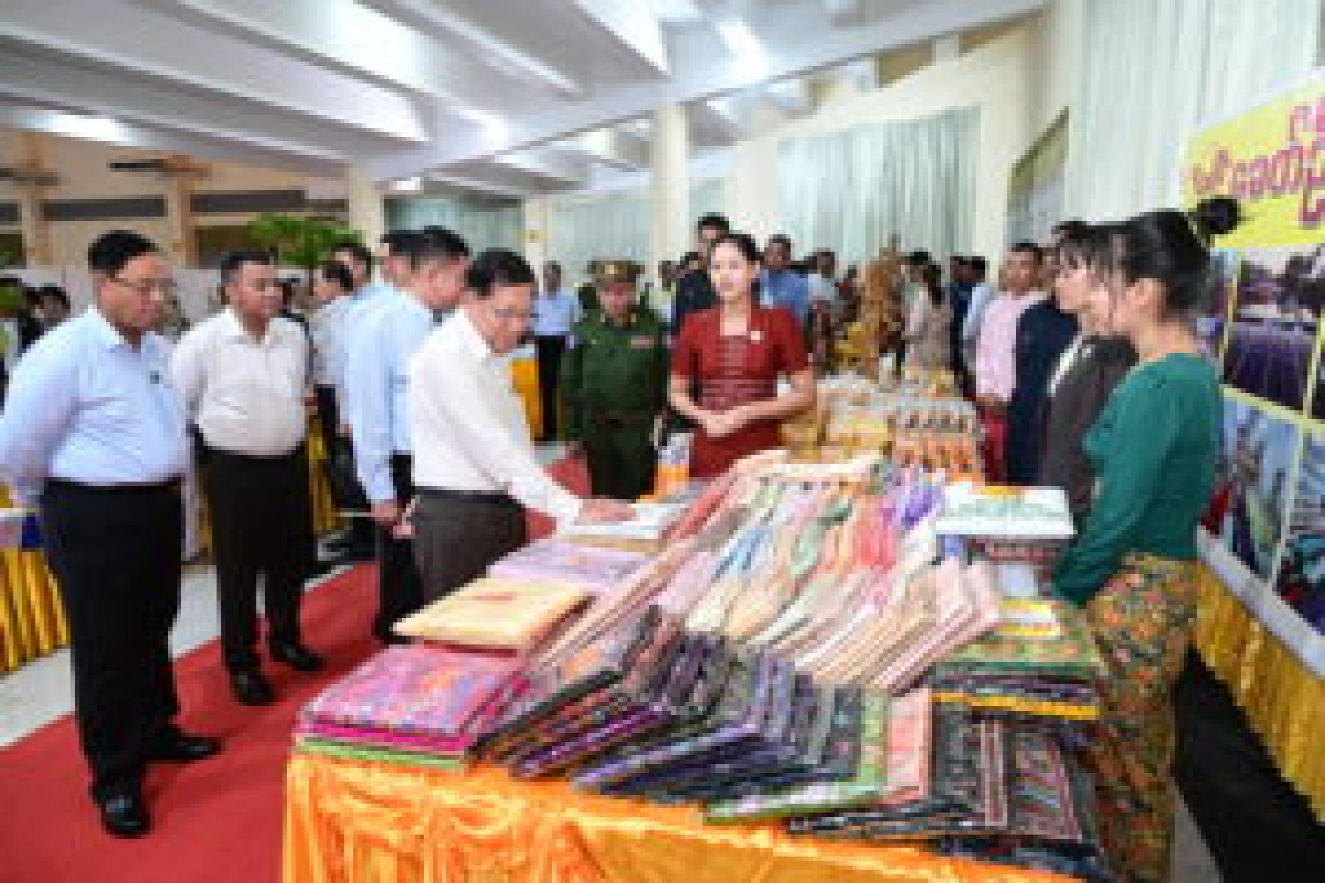 缅甸联邦共和国代理总统、国家安全与和平委员会主席敏昂莱大将17日在毛淡棉中小微企业展览会的展位上参观了纺织品。