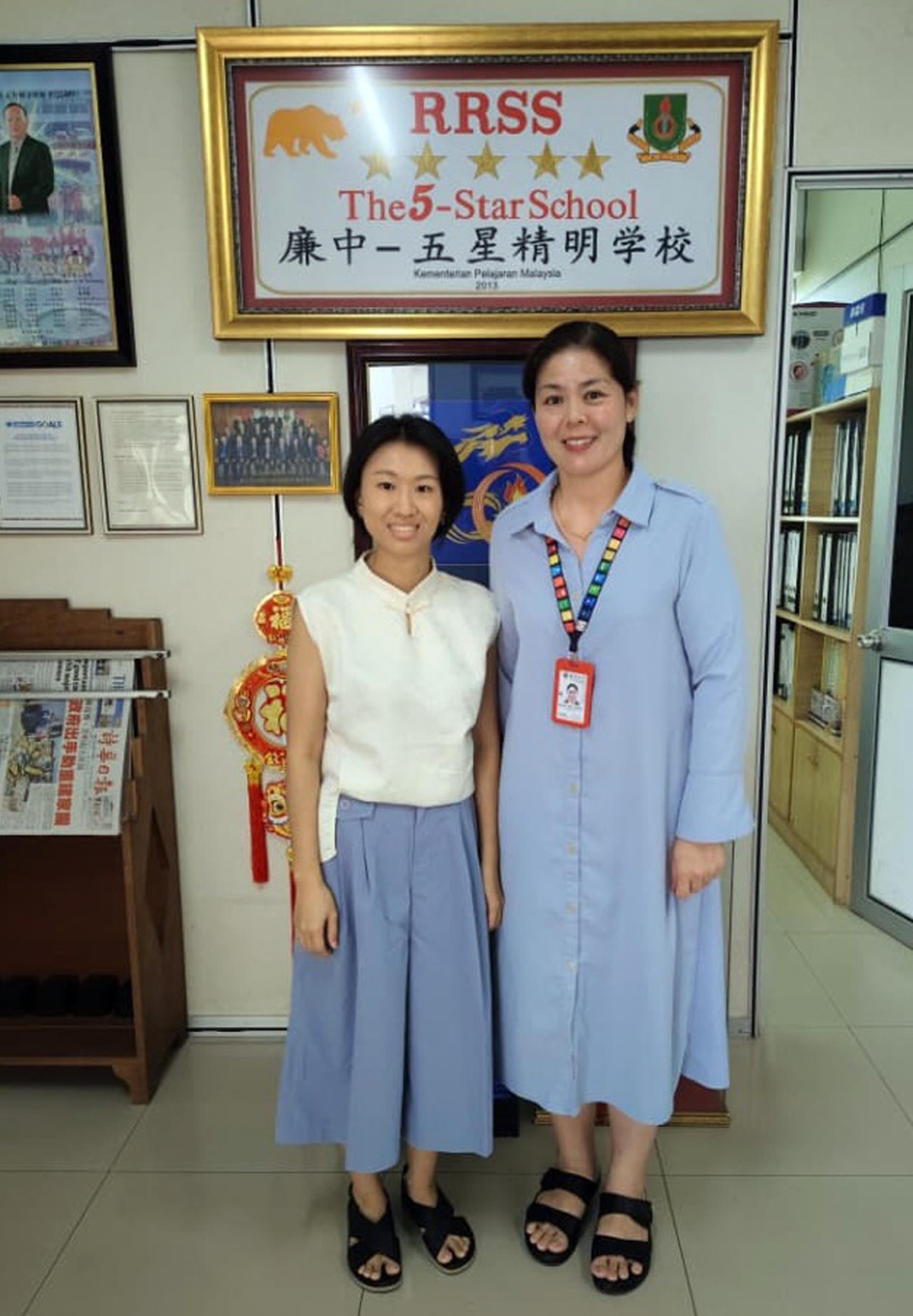 郑婉芬老师与江佩娟校长合摄，并鼓励小六家长将孩子送入廉中就读。