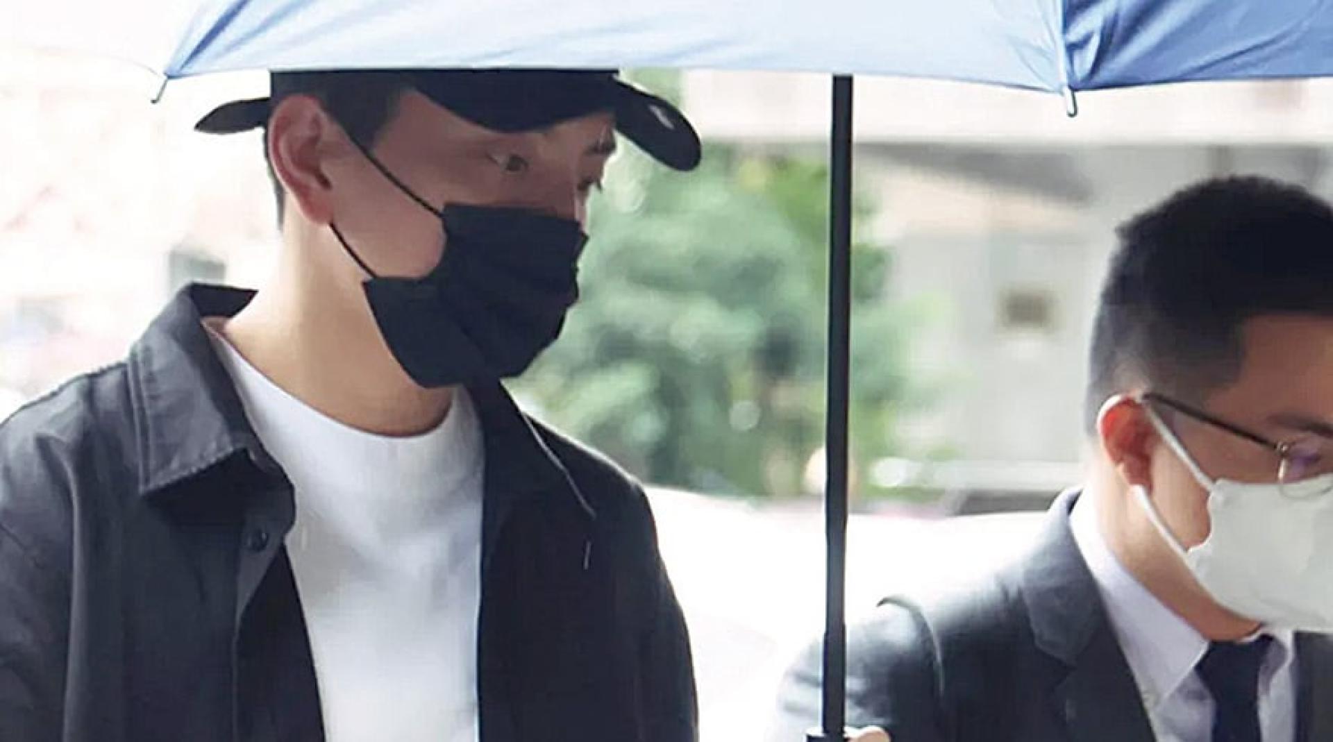 王大陆为闪兵案出庭，撑着伞不发一语。