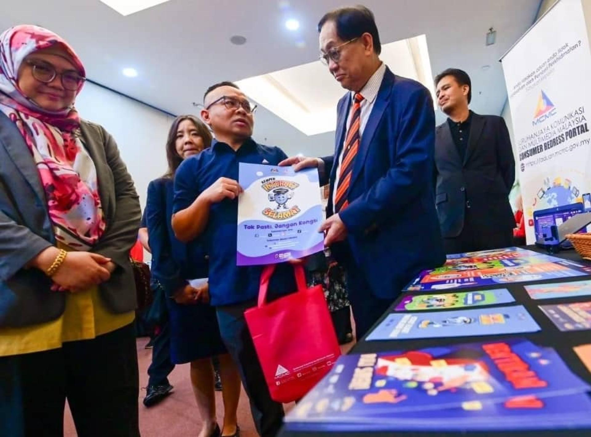 拿督法兰西哈丁（右）颁发纪念锦旗给参与者。