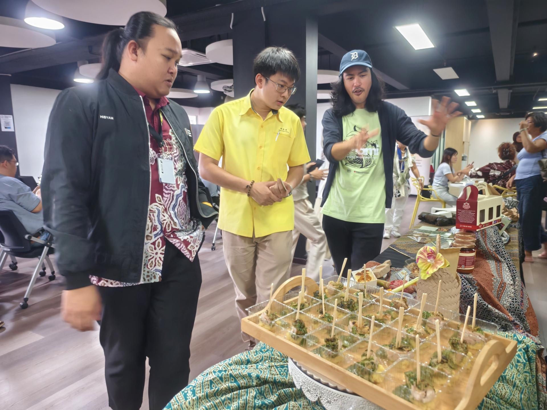 SAGO 集团董事阿里夫（右）向砂旅游部副部长拿督陈超耀的代表谢家洪（中）介绍学员的食品。