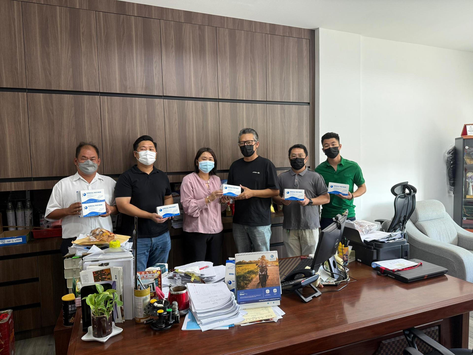 人联党珠巴分部青年组组长余忠明（右3）移交口罩予培民中学校长贝美娇（左3）。