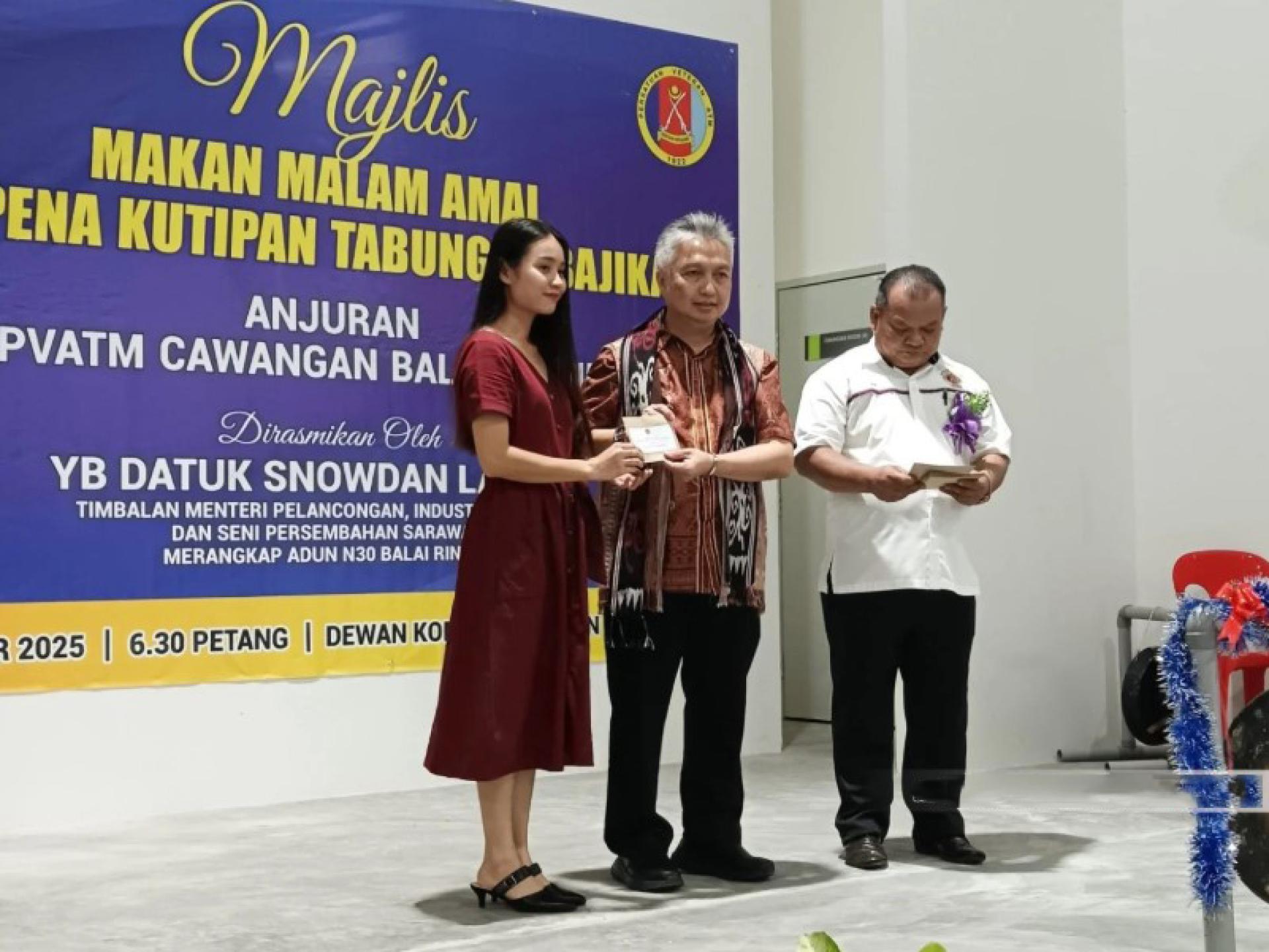 斯诺登（中）向其中一名受助者颁发援助。