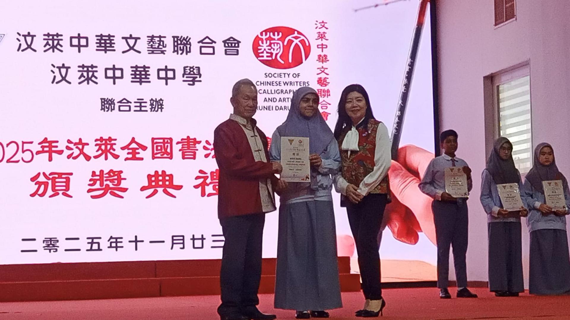 孙德安颁奖了书法比赛优胜者，右为筹委会主席陈丽珍