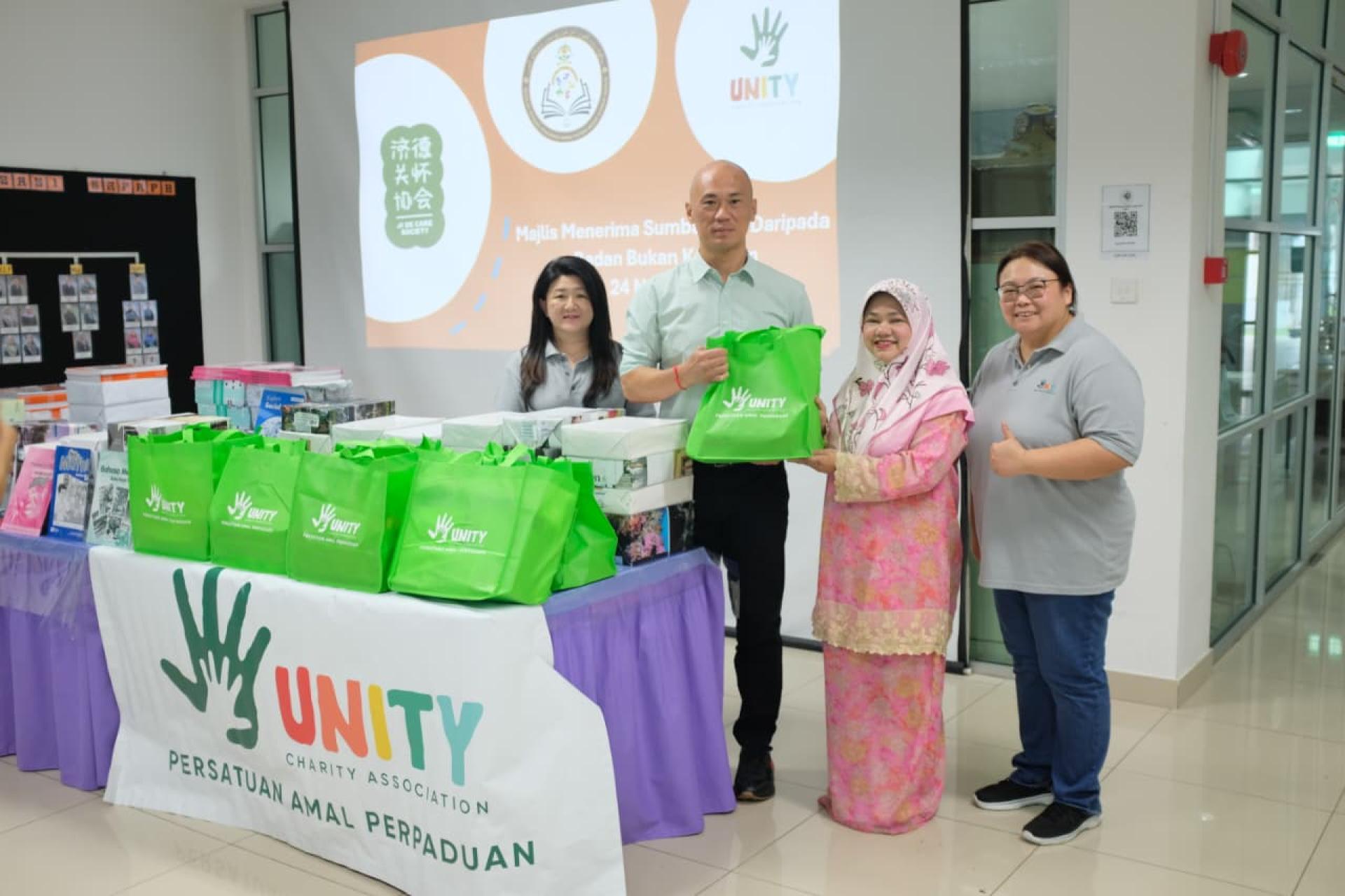 吴吉星会长移交作业本及文具予校长，左为吕诗韵秘书长、右为郑世娟福利主任