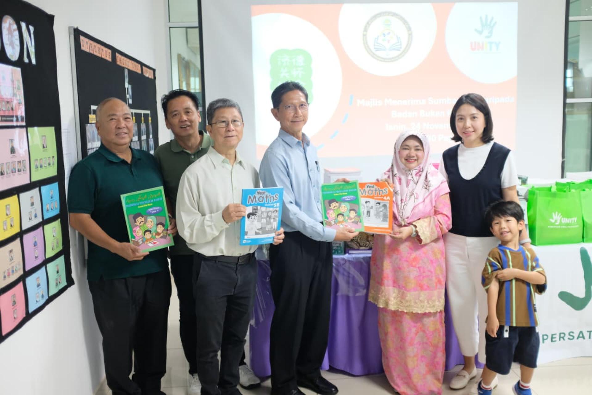 济德关怀协会代沈忠祥移交书籍予校长Asnawati，左起洪锡福、庄宝明、沈仁祥，右为沈媛