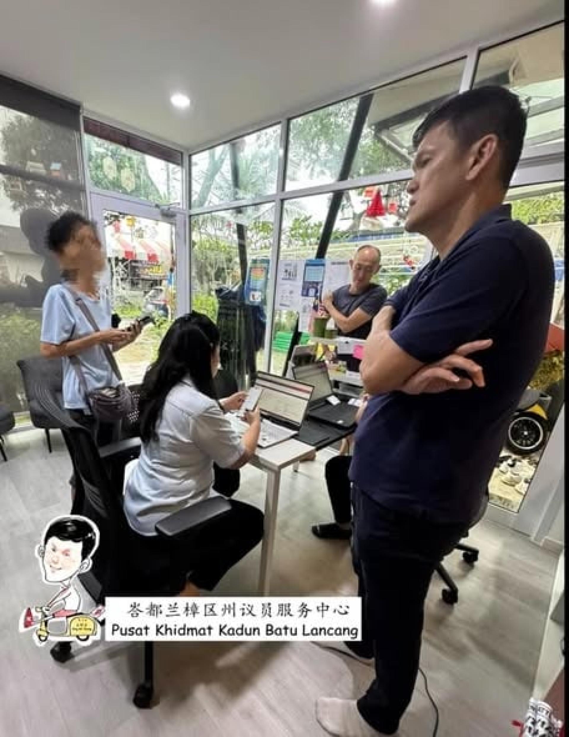 有民众（左站者）直接到王耶宗服务中心求助。王耶宗（右前站者）说，目前尚有约1000名大马人滞留泰南，在等待救援。