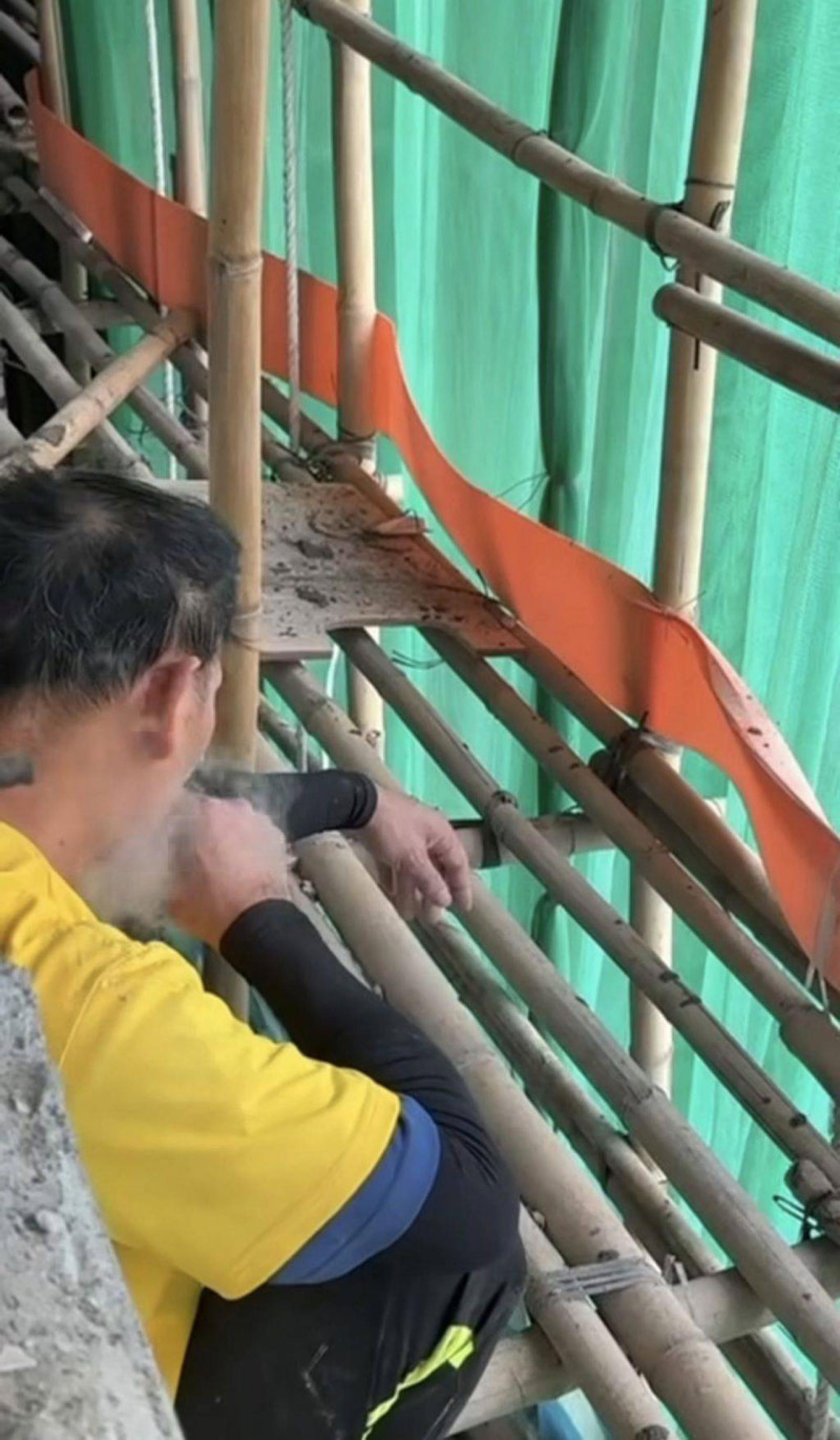 有居民发现大楼棚架上的工人吸烟。