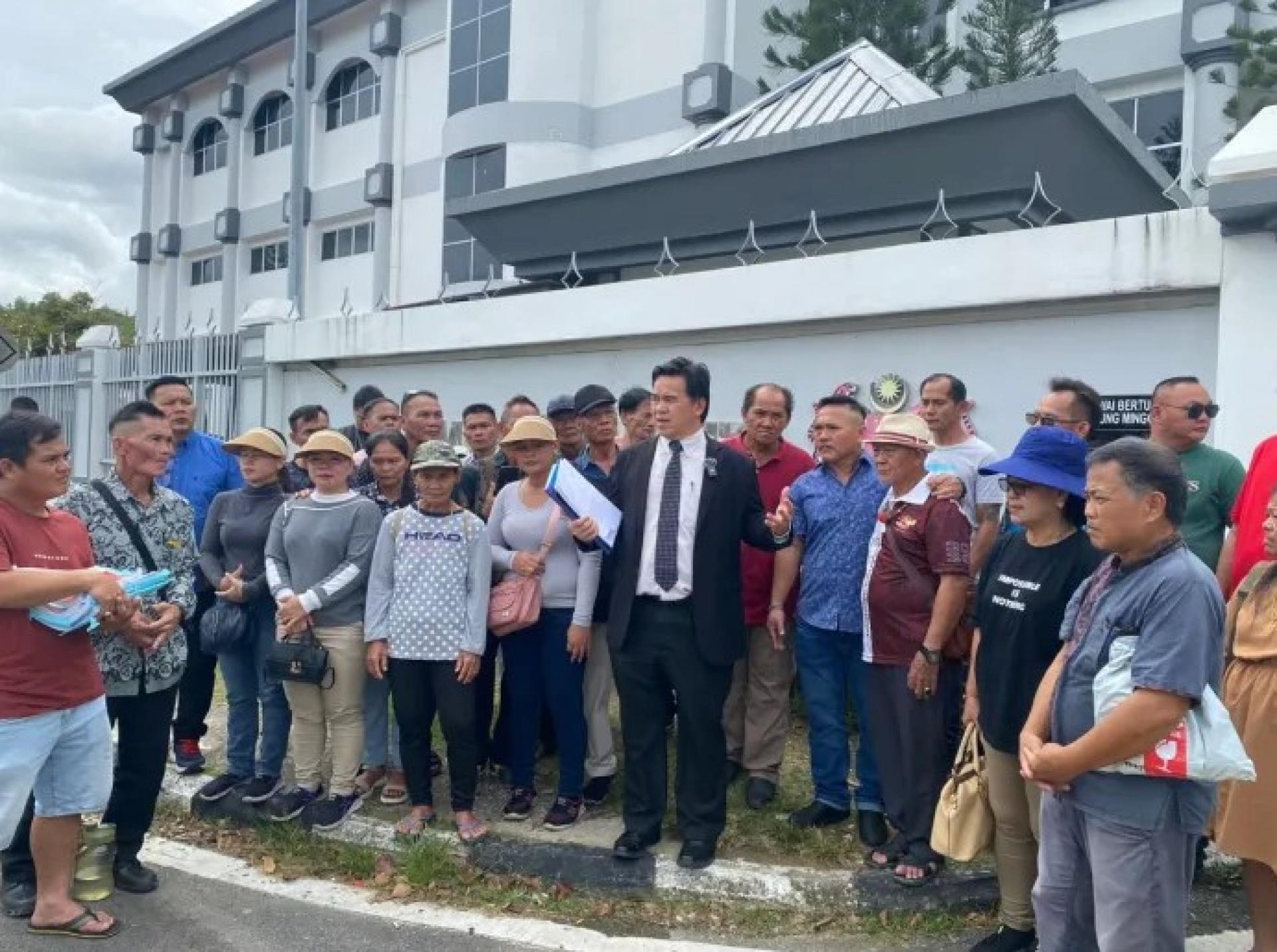 2025年11月26日案件过堂后，罗兰恩甘（中）在美里法庭综合大楼外向到场声援的本南支持者讲解案情。