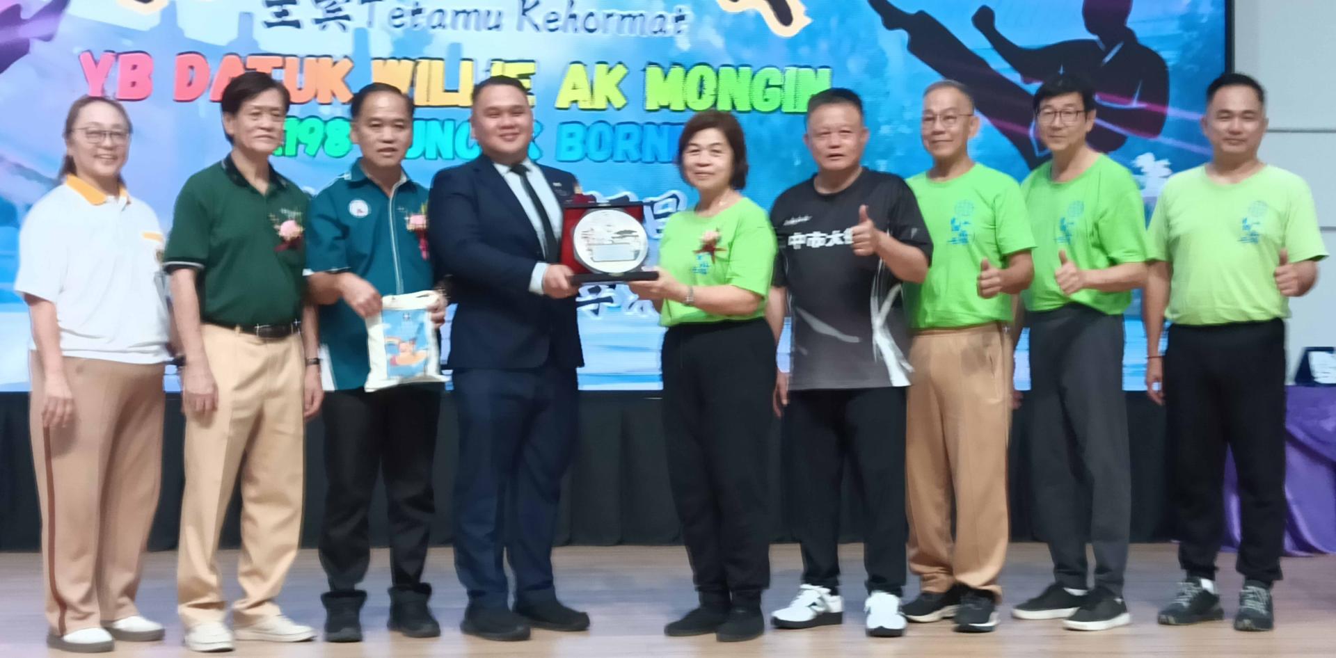 马来西亚外丹功总会中委兼本次教练团团长拿汀罗水莲从邱暨幸手中领取纪念品时摄。