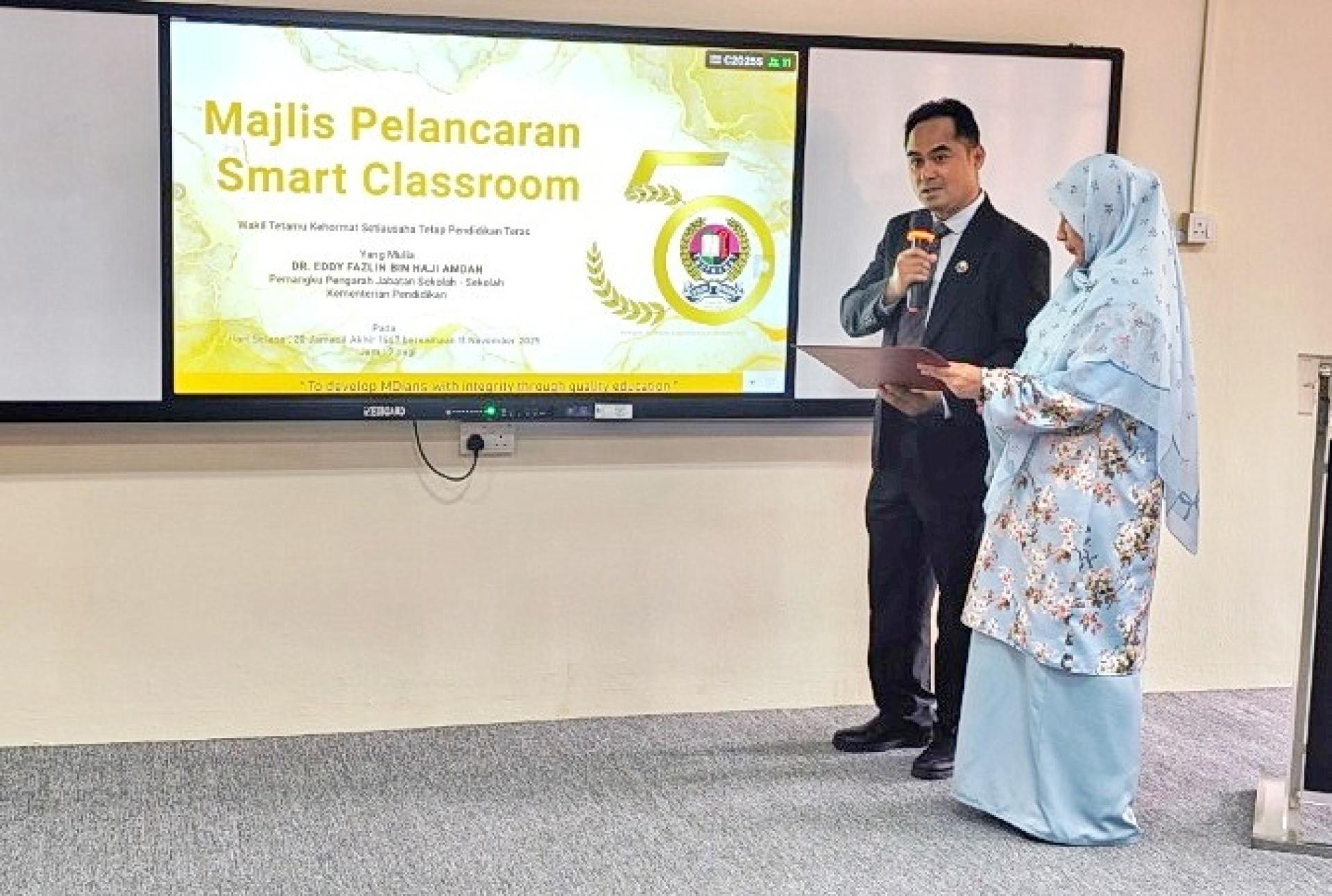 教育部属下学校局代局长艾迪法兹林（左）主持智慧教室正式启用仪式。右为皇太子学院院长努拉玛利亚蒂法。