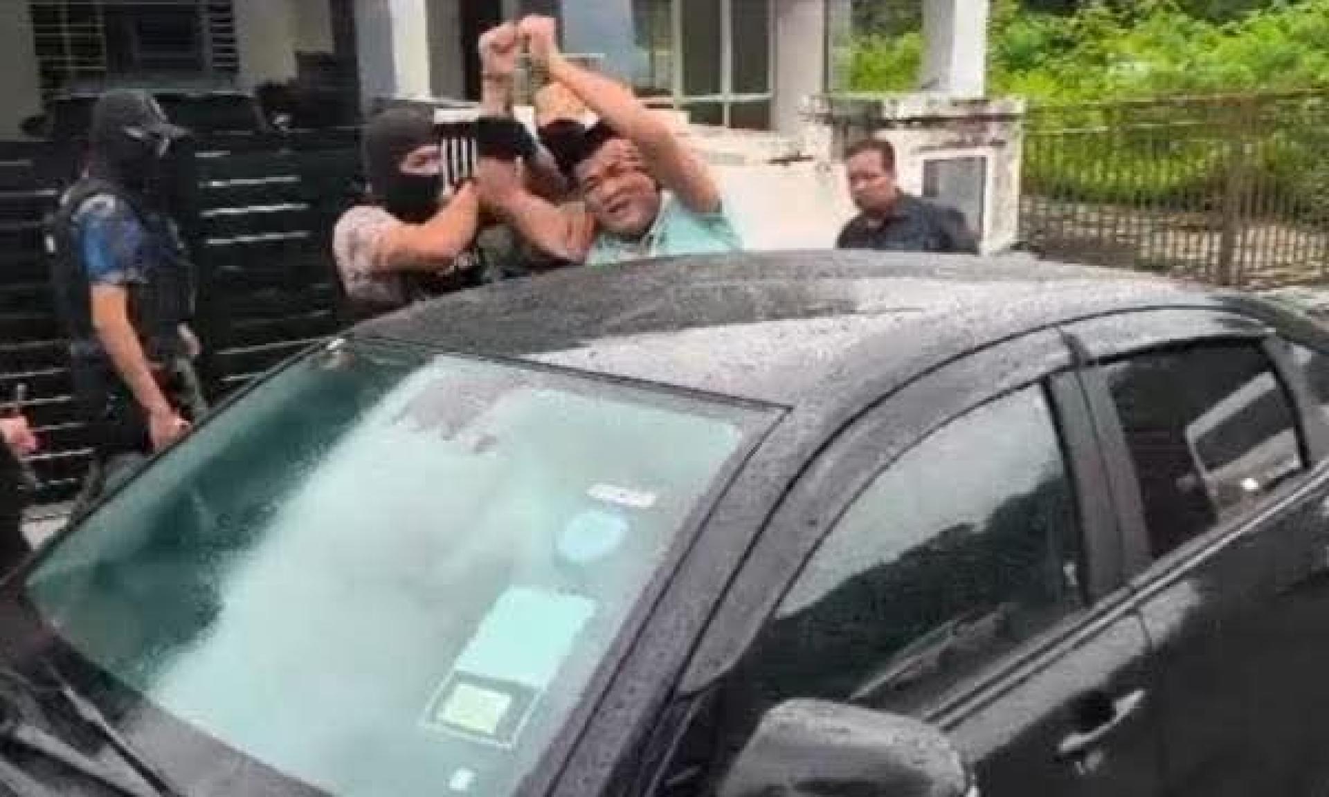 不甘被捕的刁健城，高举上铐的双手，大喊“抗争到底”，惟仍被全副武装的反贪会官员押上车。