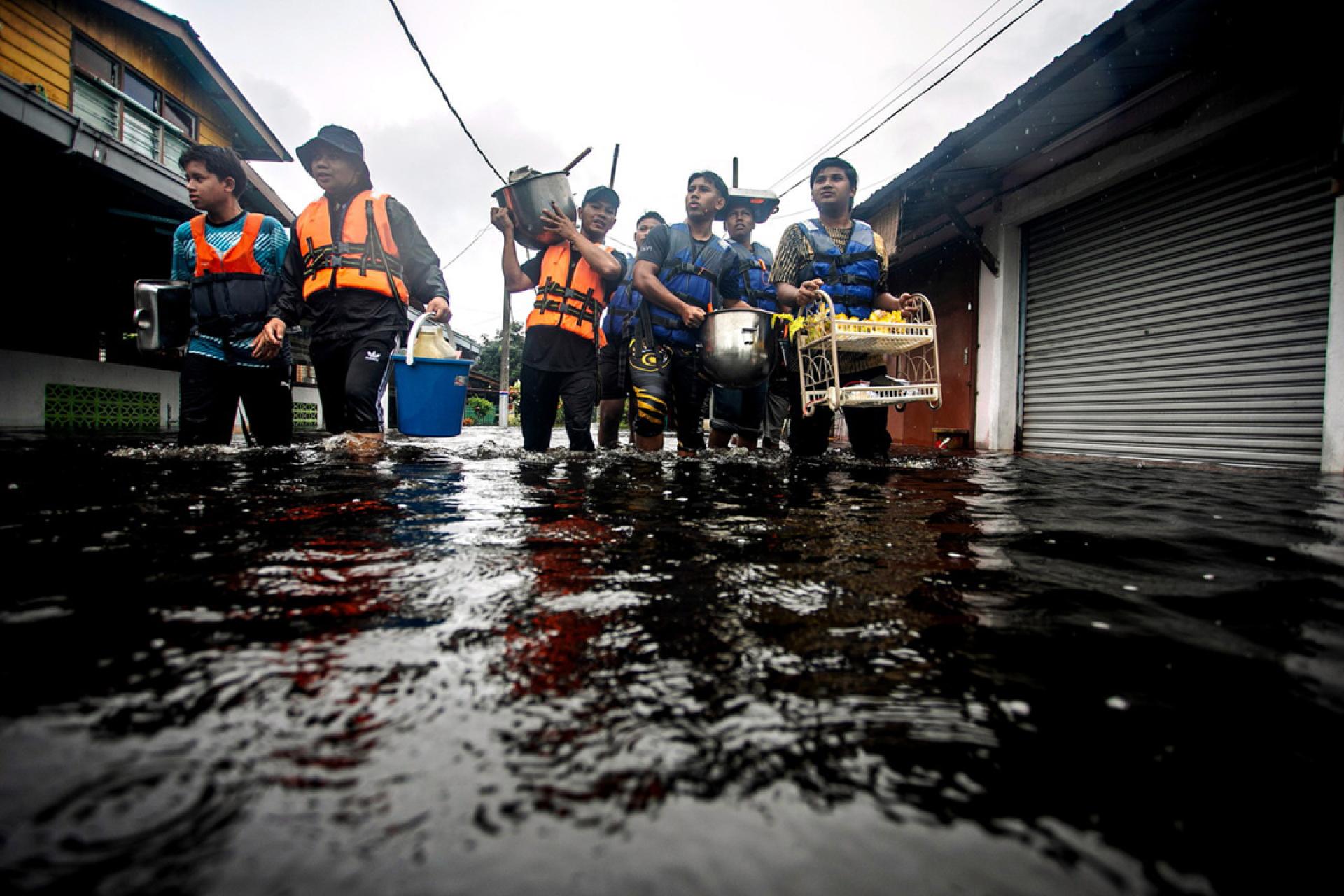 在安顺甘榜Selabak ，志工们涉水进入村庄，协助村民把家中的日常用品带往疏散中心。