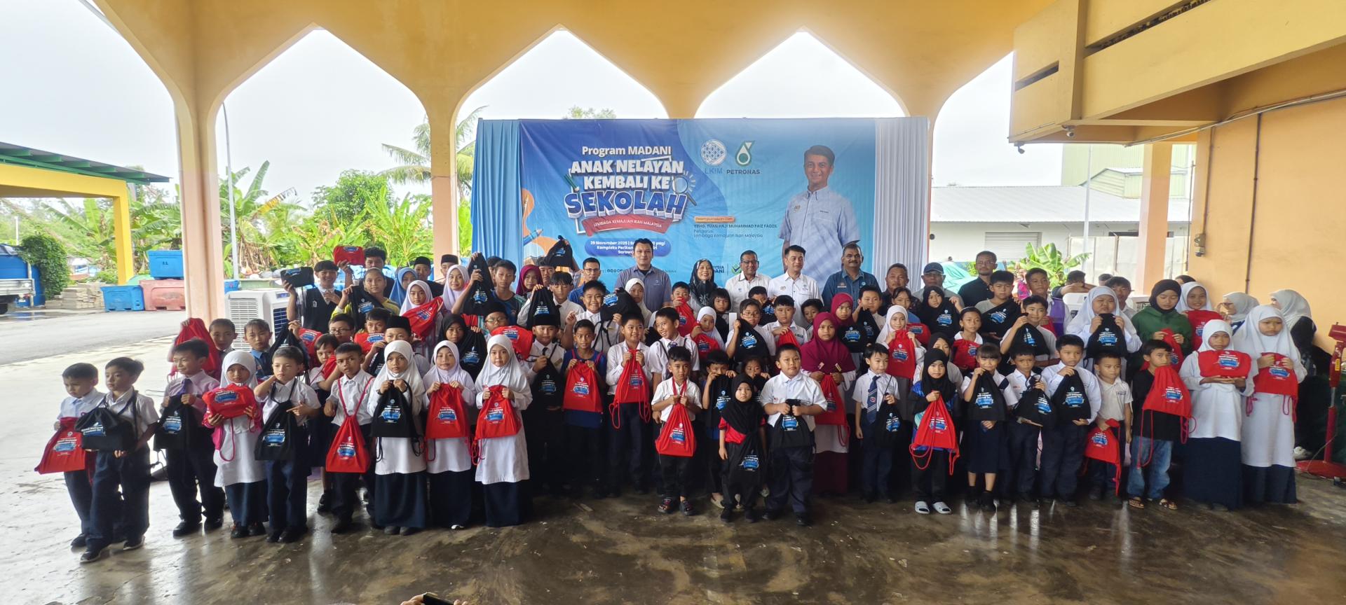 马来西亚渔业发展局与马来西亚国家石油公司（Petronas）合作举办渔民子女返校活动，100名美里渔民受惠子女在领取助学金后，与嘉宾一起合照。