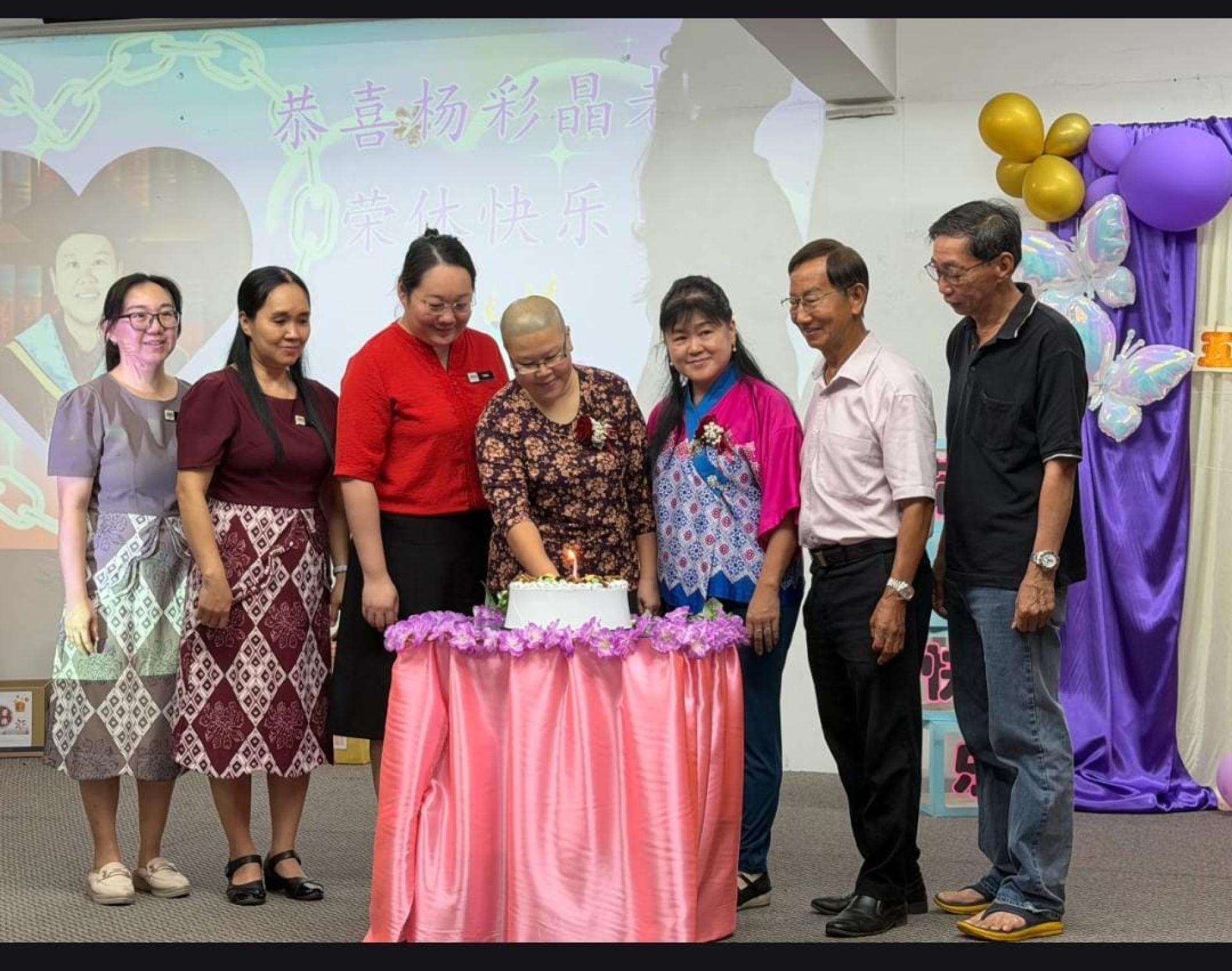 五哩八港中公校董会赠送一个（精美的荣休蛋糕）予杨彩晶老师。左起为五哩八港中公辅导班老师林秀娥、学术主任吴玲玲、校长郑觥桦、荣休老师杨彩晶、恩师魏惠香、校董会主席沈观伟先生及校董会名誉主席李仁赵。