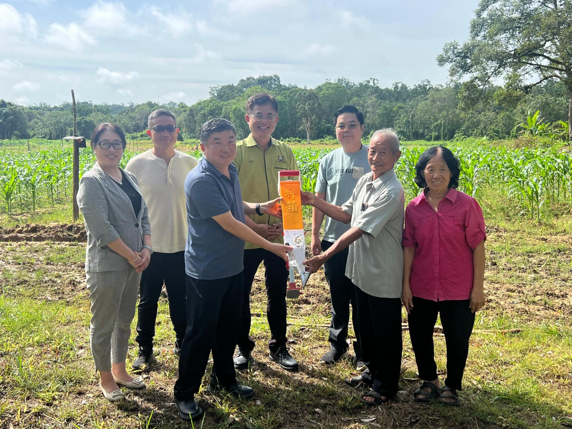 中国山东烟台中华文化促进会会长徐骏（左3）将播种器移交黄泥石先生。Sunray Agritech Sdn. Bhd.董事黄贵才（左2），古晋巴达旺市议会主席陈开（中），饲料玉米试验田项目协调人蔡宗璟（右3）。
