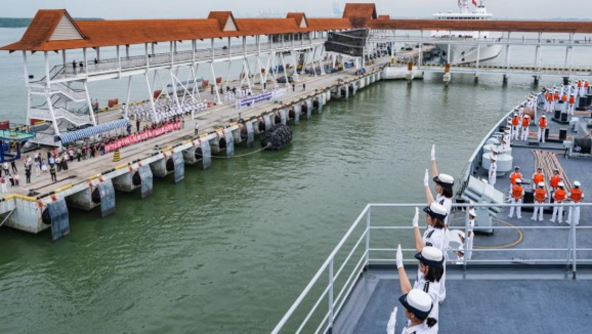 学员在甲板分区列队，向欢迎人群挥手致意。