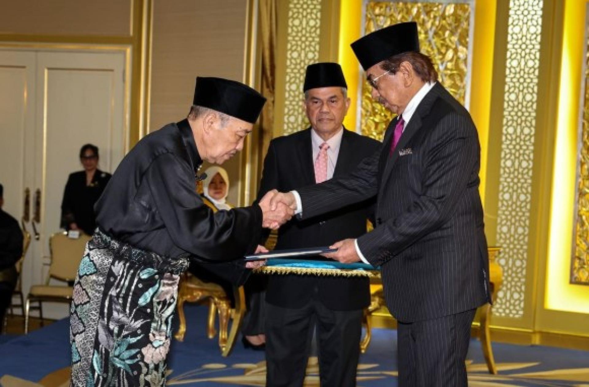 哈芝芝（左）周日凌晨在沙巴州元首敦慕沙阿曼（右）面前宣誓续任沙巴州首长。