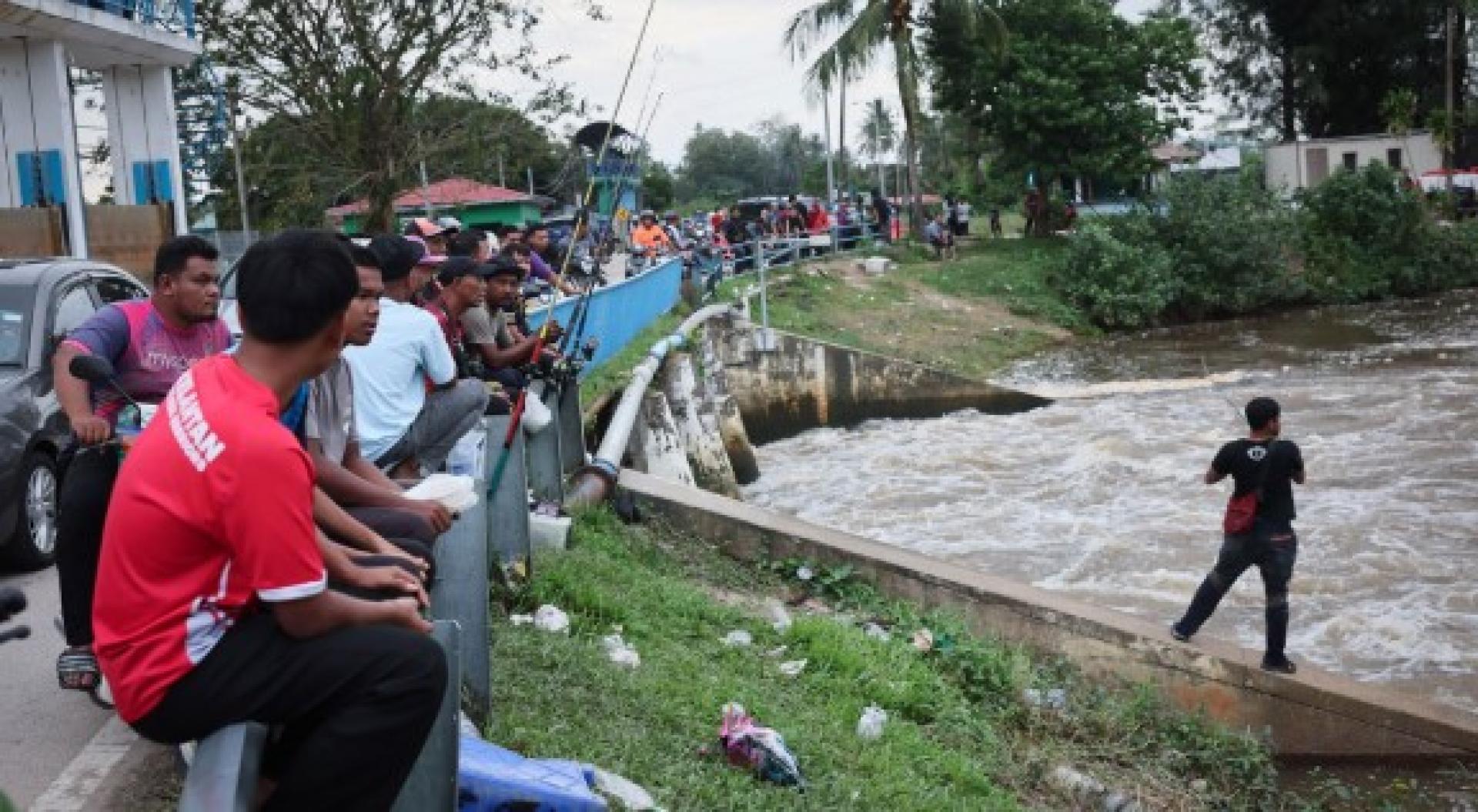 数十名垂钓者聚集河边。