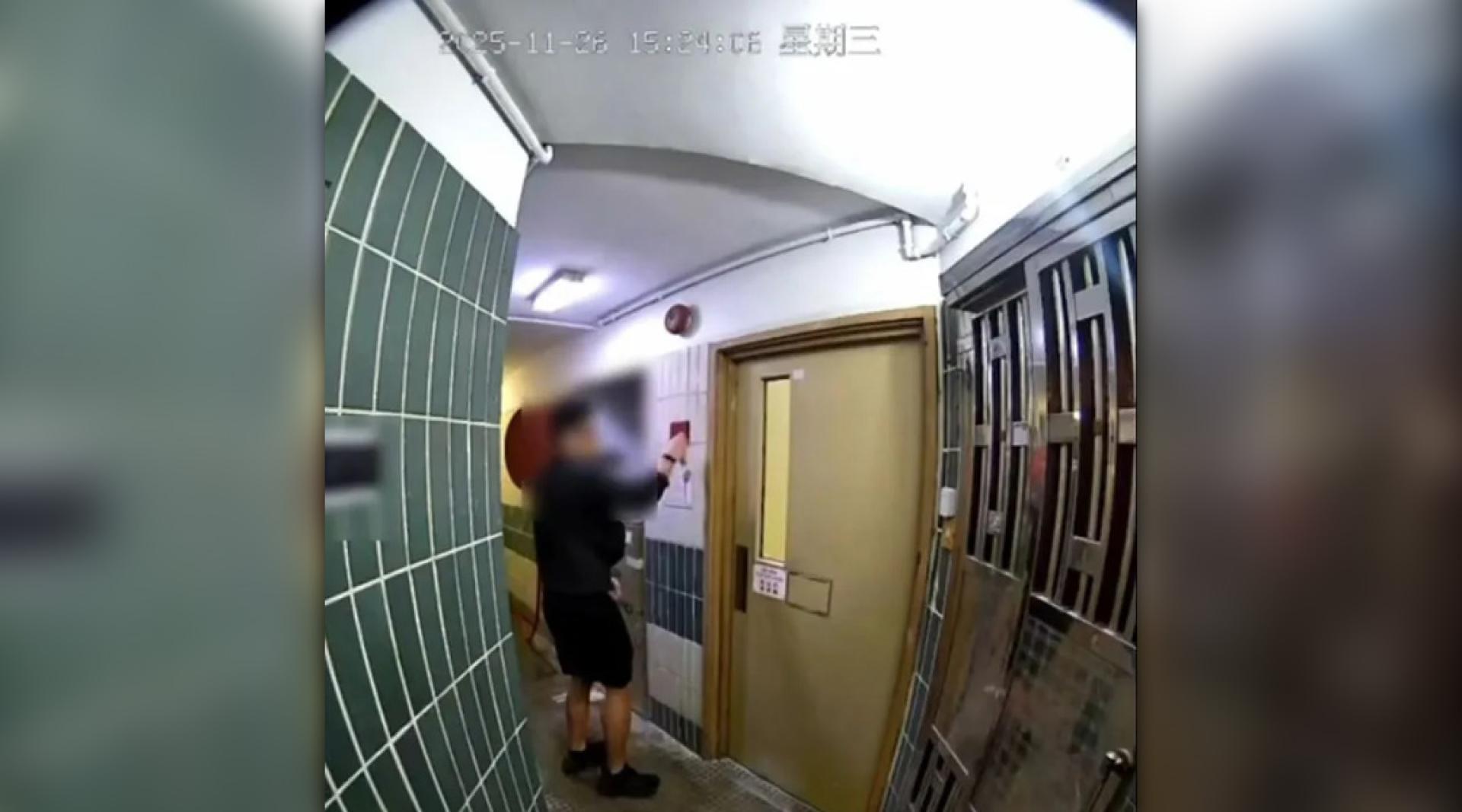黑衣男子走到走廊火警钟位置，用硬物敲打火警钟，发出“嘭嘭”声响，但火警钟未有响起。（图：Threads）