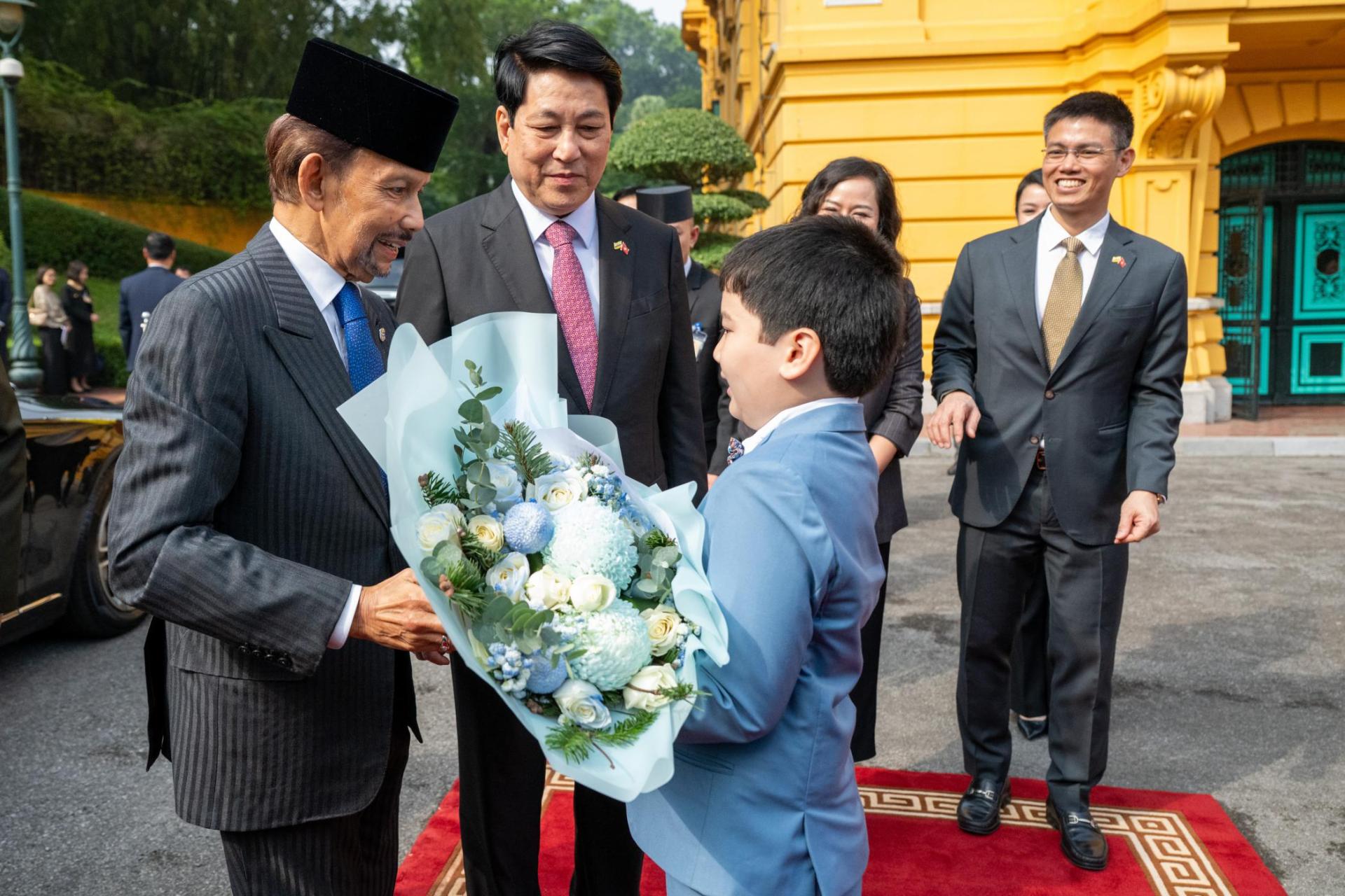 儿童向苏丹献上鲜花，中为越南国家主席梁强