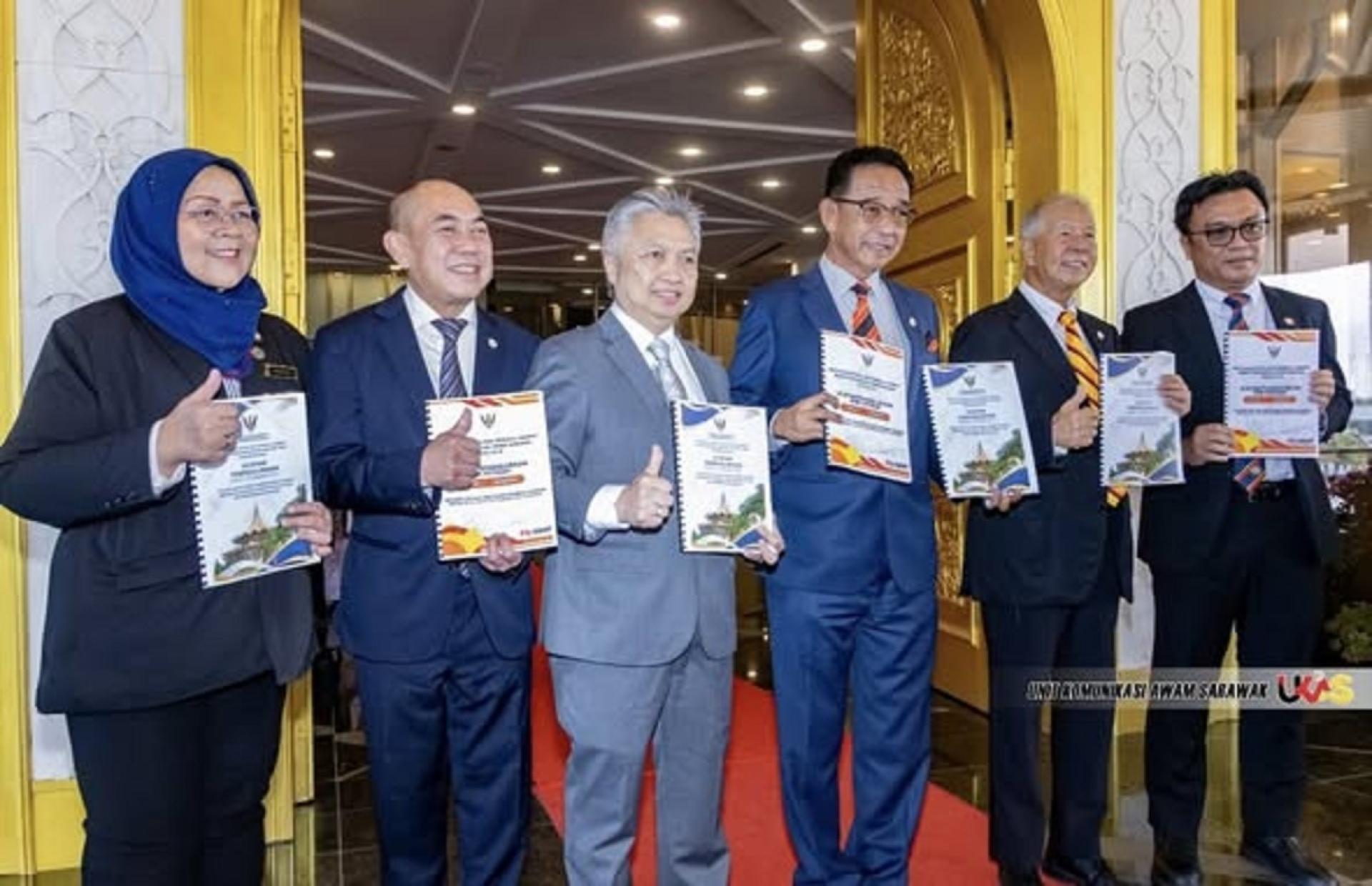 拿督斯里阿都卡林（右3）与其部门同僚们共同展示部门总结文件。