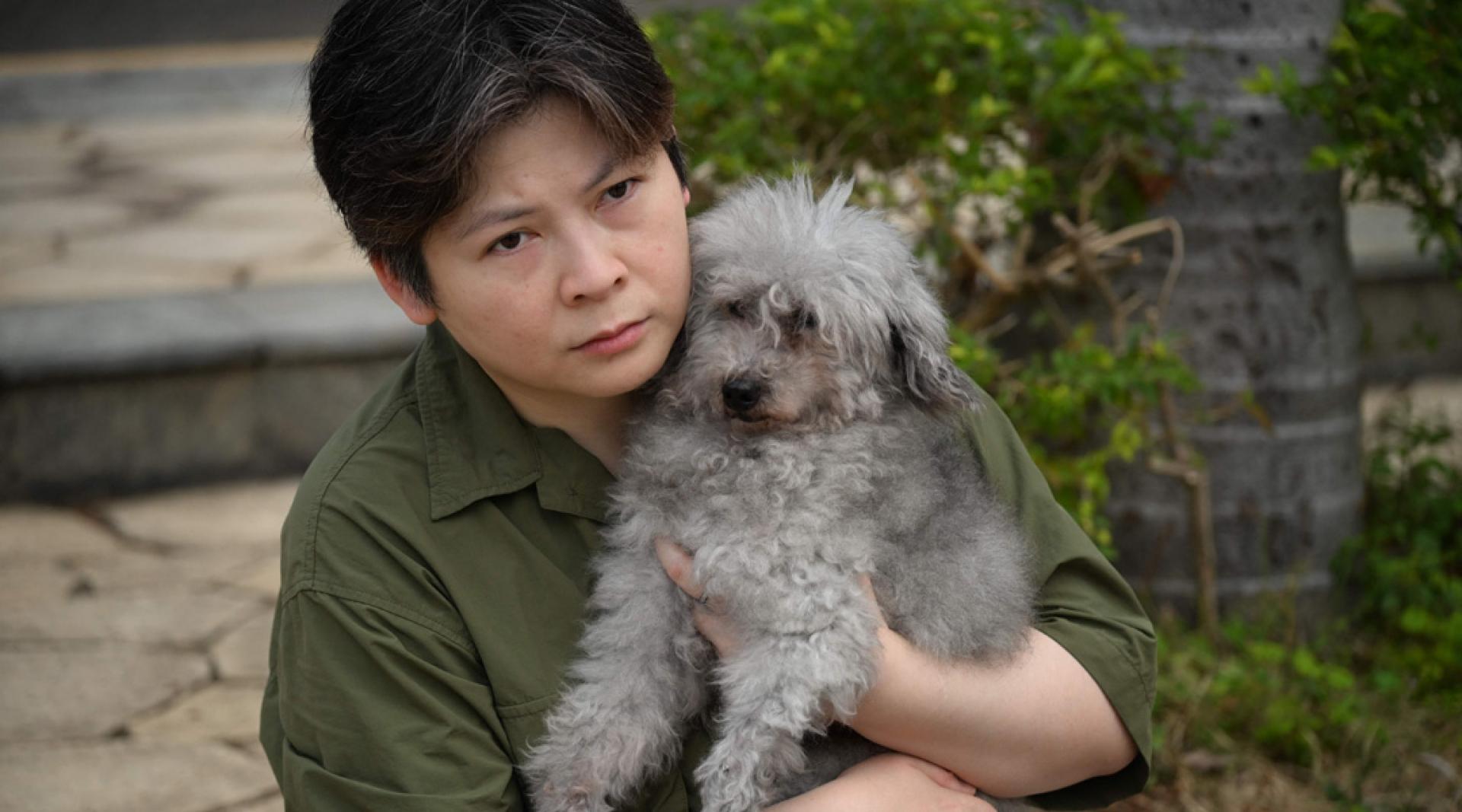 Jacky抱著逃过一劫的15岁爱犬。